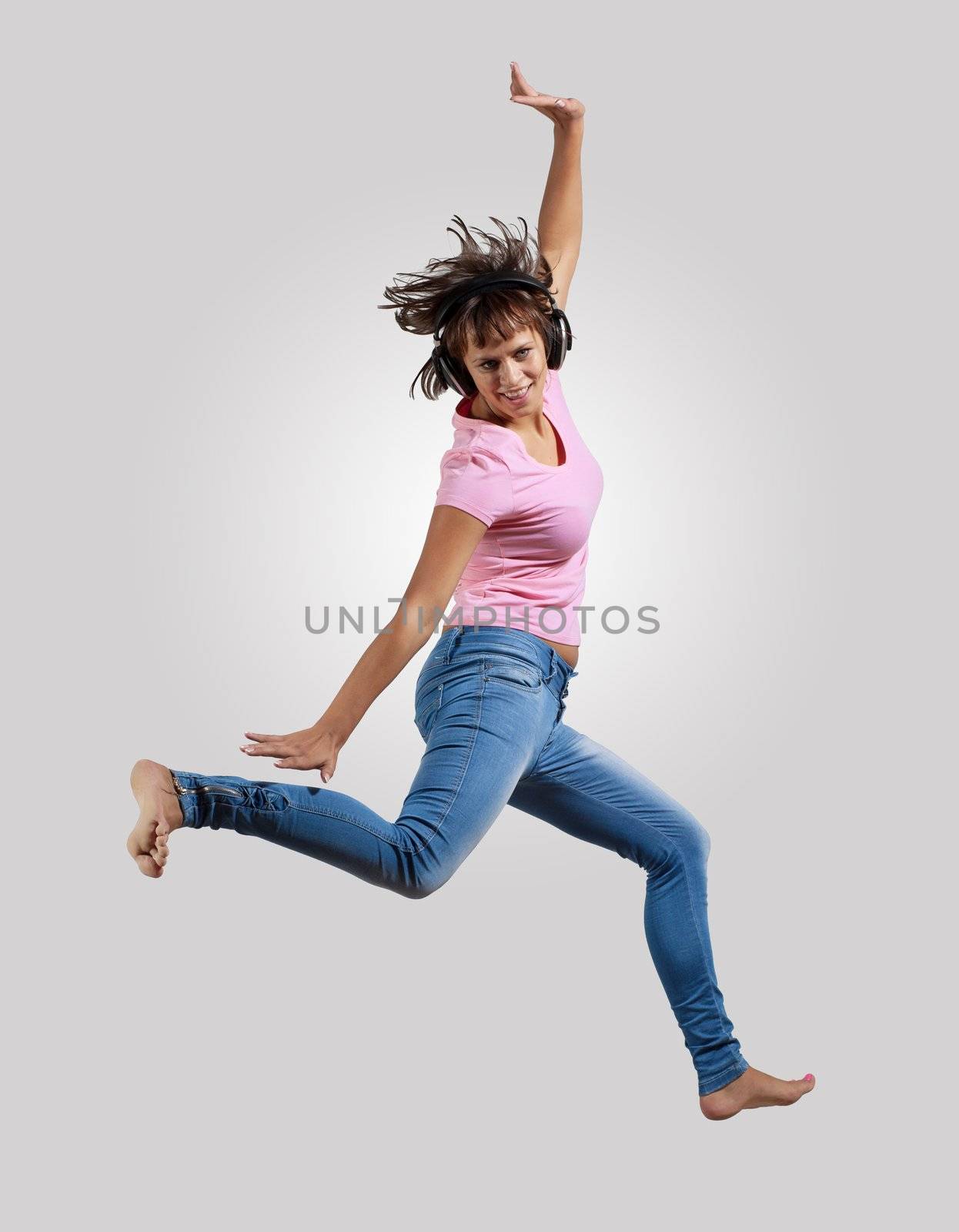 pretty modern slim hip-hop style woman jumping dancing on a grey background