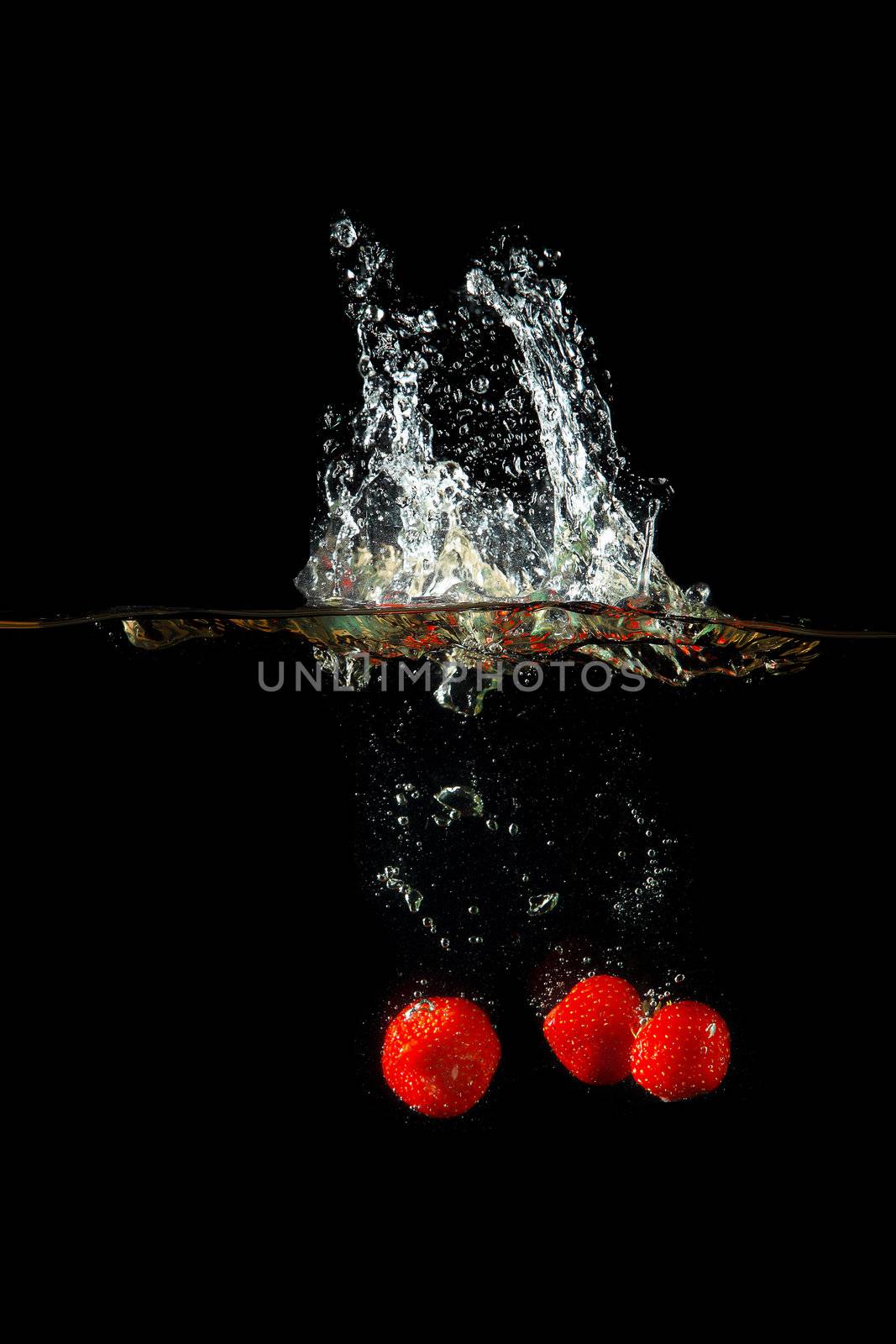 Colored red paprika in water splashes on black background