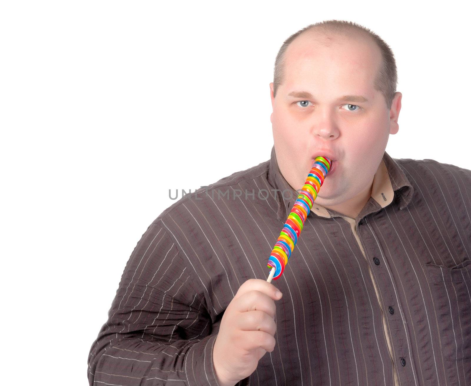 Fat obese man enjoying a a long colourful striped lollipop
