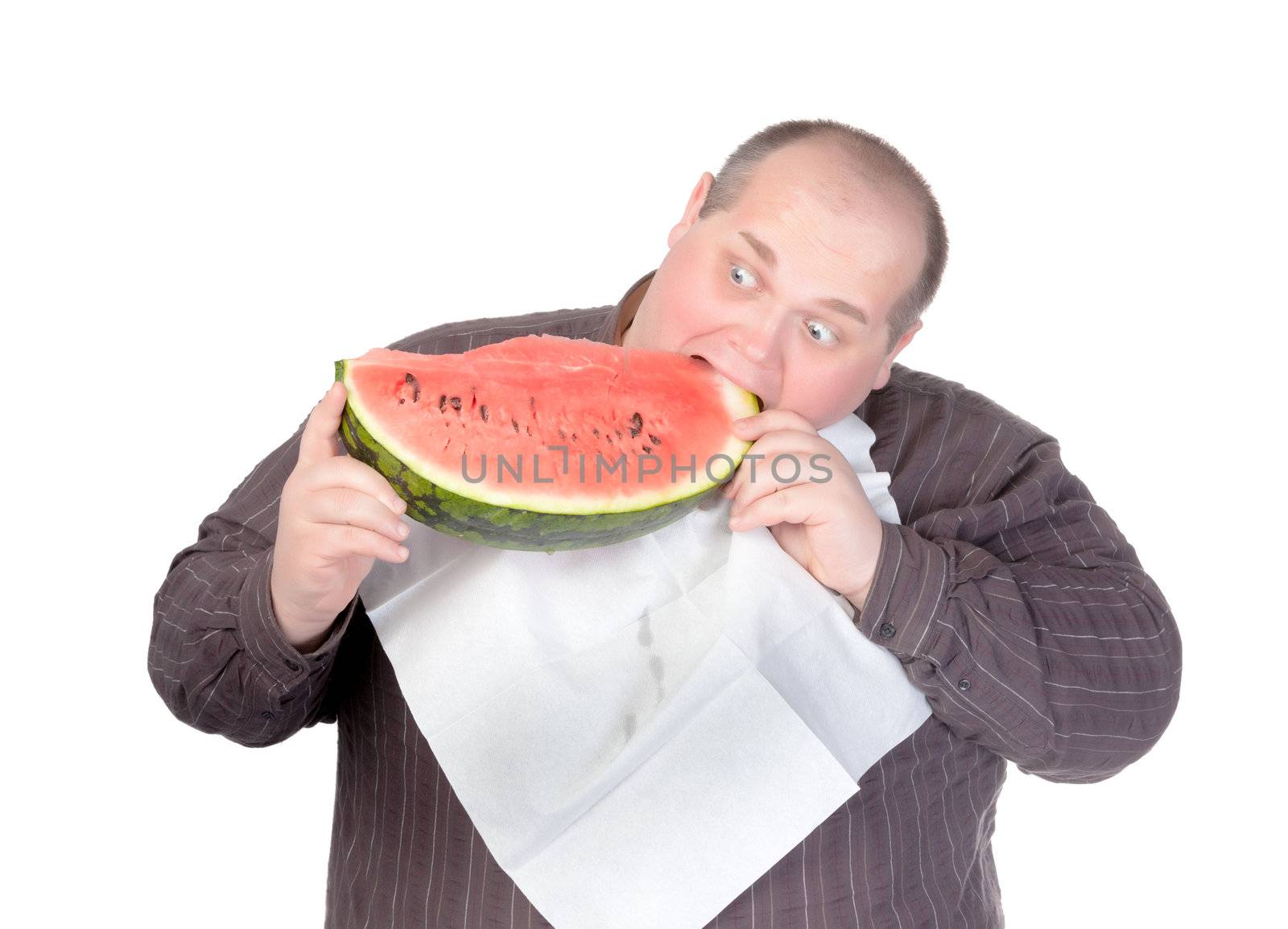 Fat man with a serviette around his neck as a bib tucking into a large slice of fresh juicy watermelon with a look of anticipation and glee isolated on white