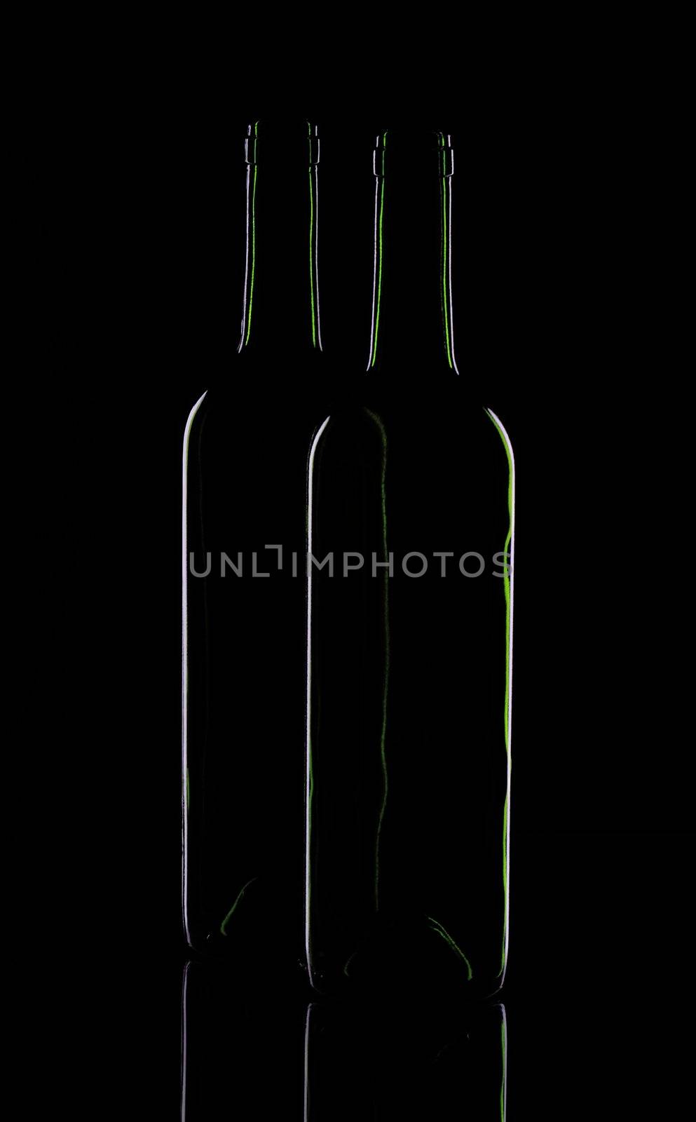 Two wine bottles on a black background
