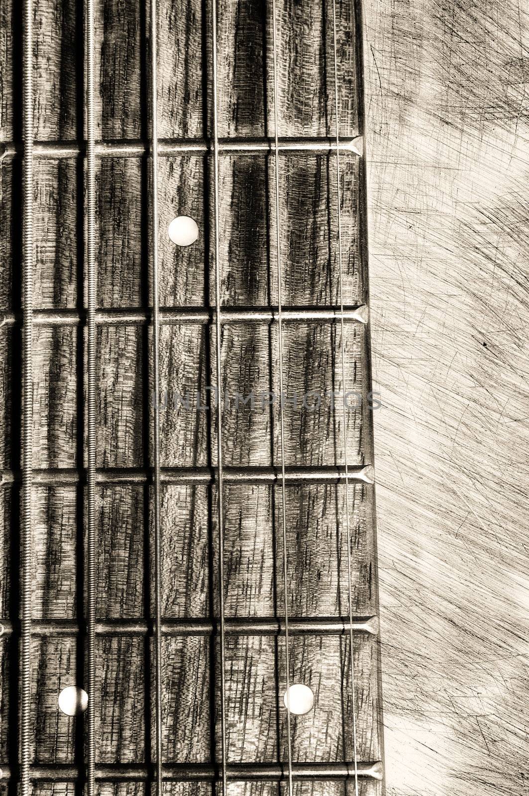 Guitar neck fingerboard on textured background, close up view