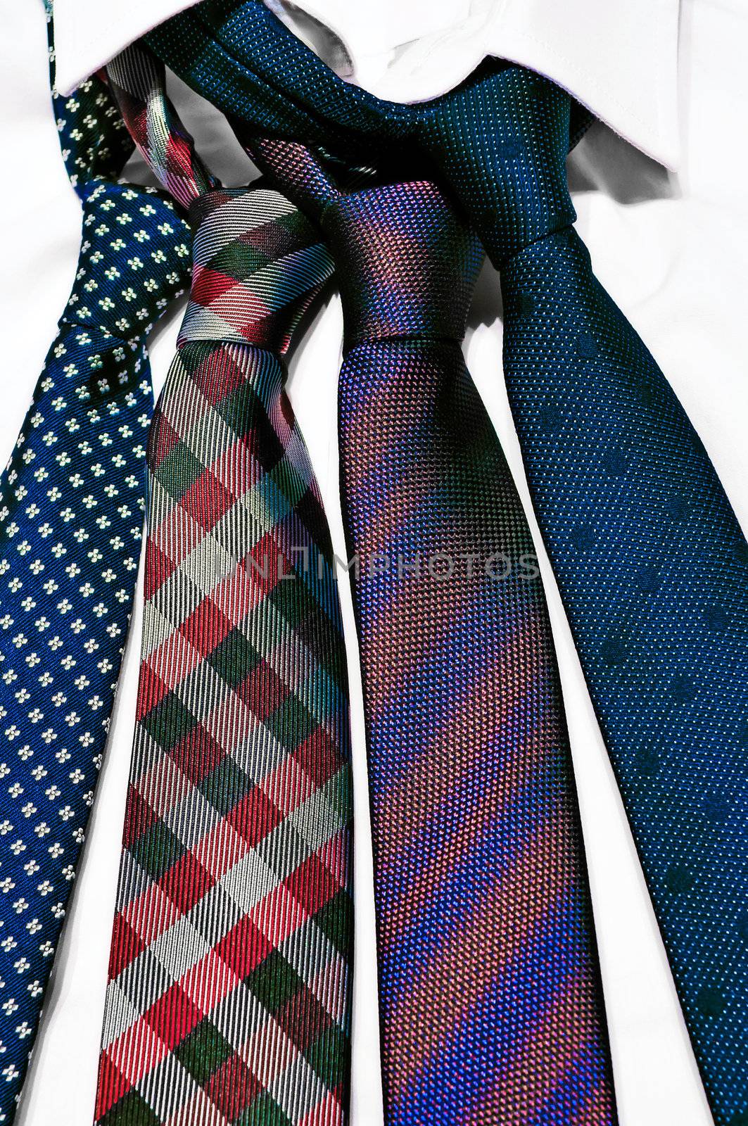 Stack of neck ties on white shirt, business concept