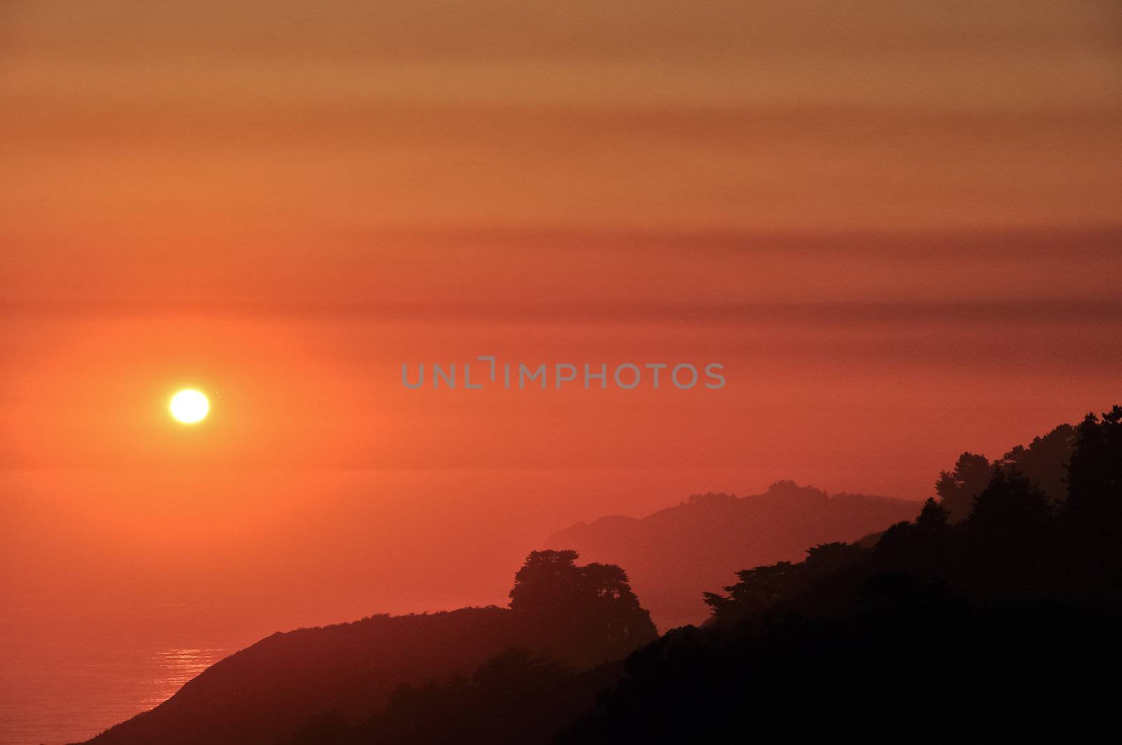 California Big Sur coast orange sunset with mountains silhouette, California, USA