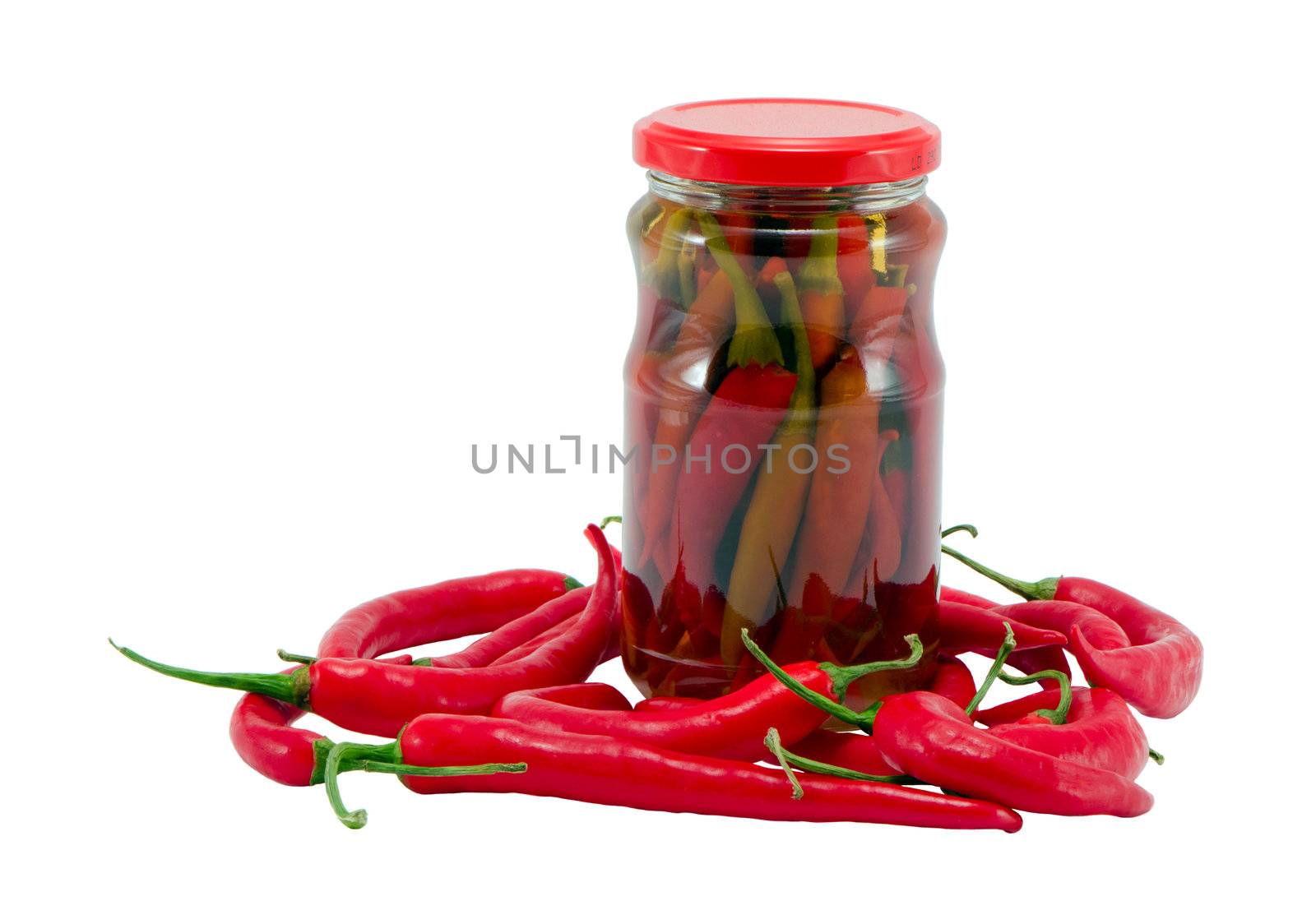 Red hot chilli pepper paprika preserved in glass pot surrounded by natural ones. Healhy ecologic food. Resource for winter time.