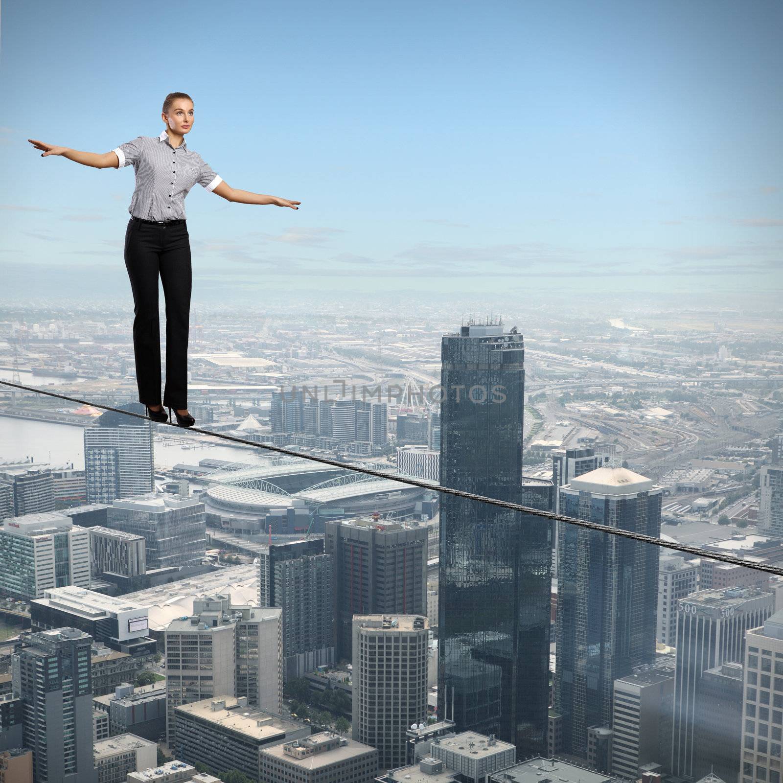 Business woman balancing high over a cityscape