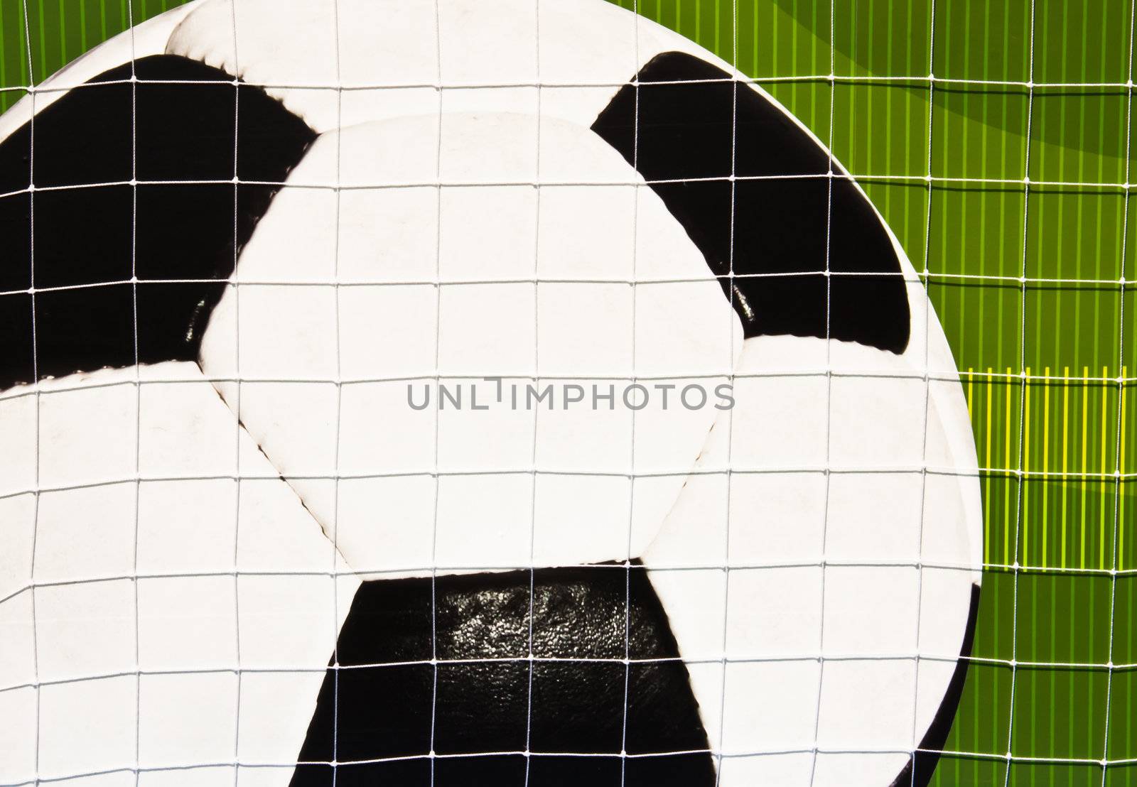 Soccer ball on the green wall. Block  a mesh barrier.