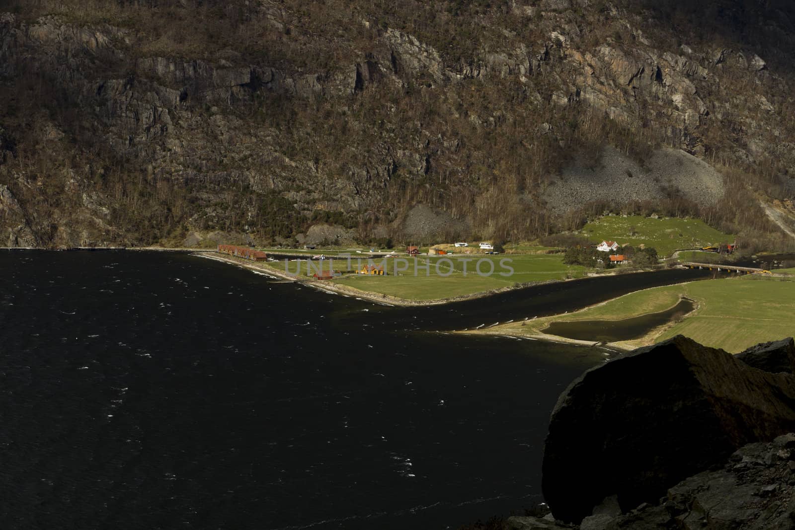 small, deep fjord in norway in changeful weather with cloudy sky