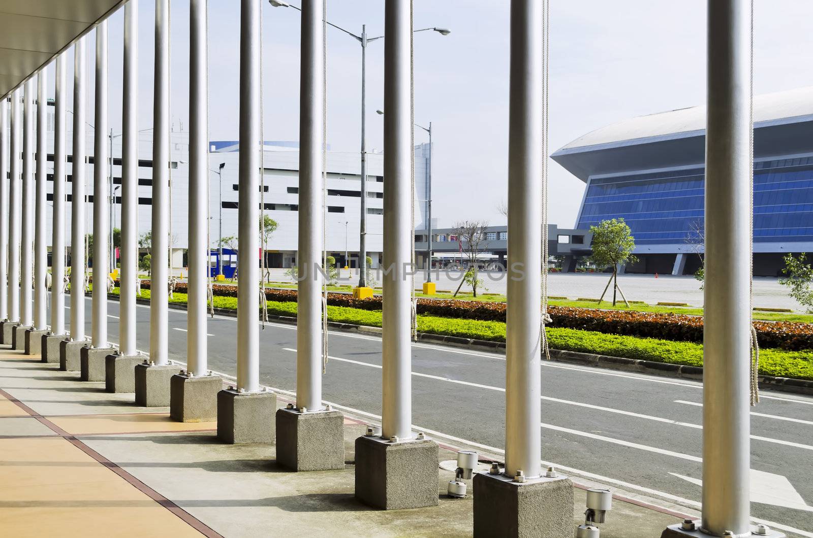 A line of flag poles on the sidewalk 