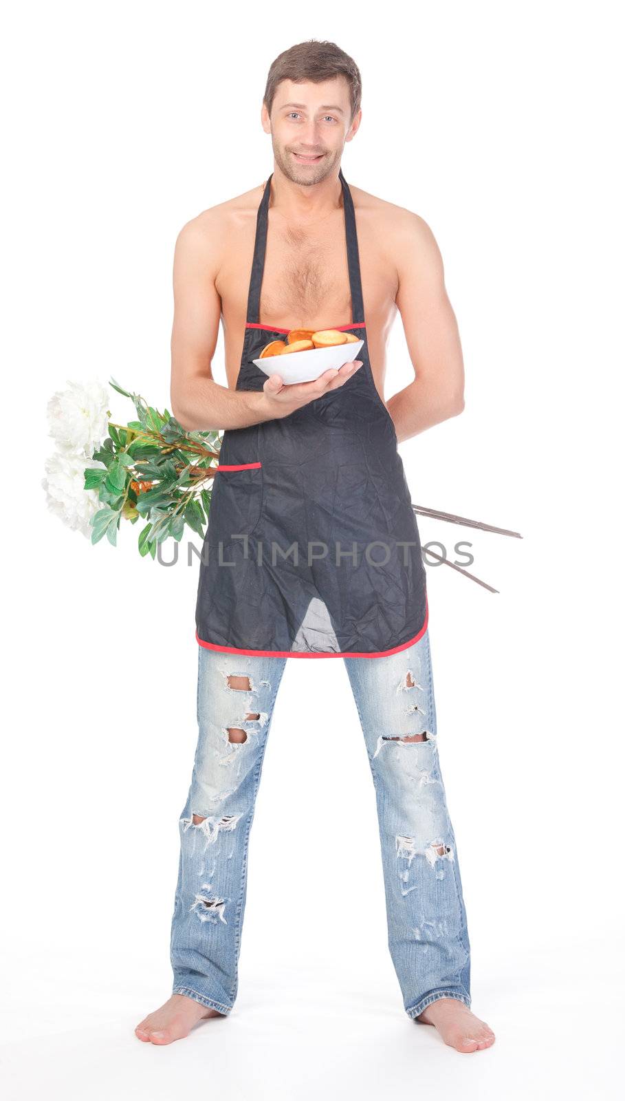 Humorous image of a handsome shirtless man barefoot and in ragged jeans wearing an apron and carrying flowers and cookies as a Valentines or anniversary gift