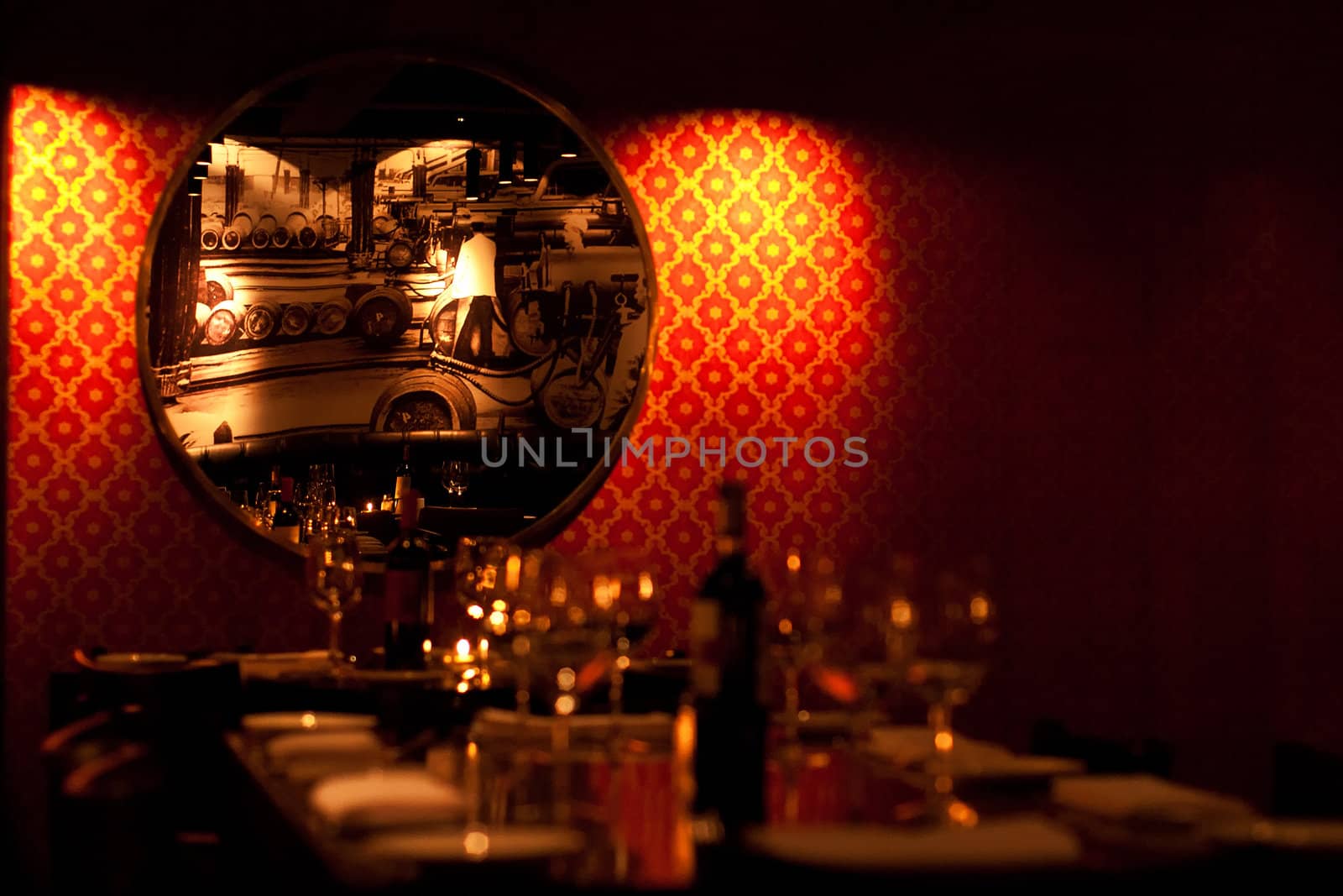 A beautifully set dinner table set against a red wall.