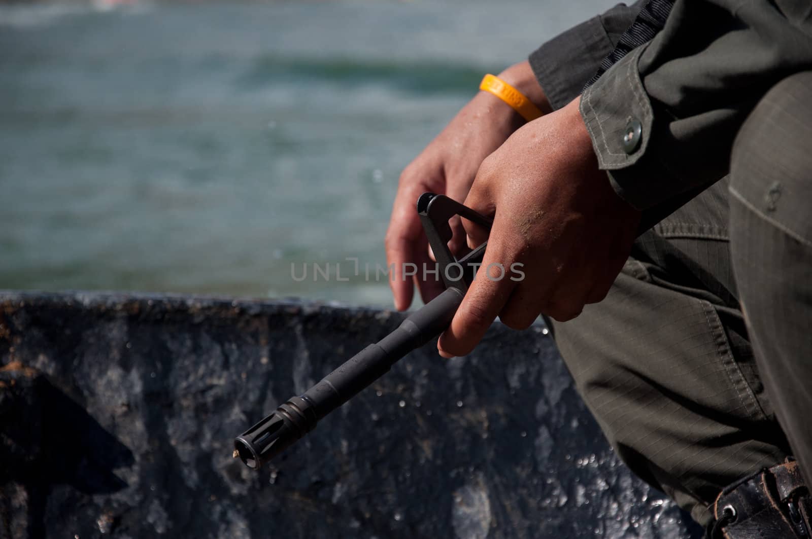 gun in hand of asian soldier in boat