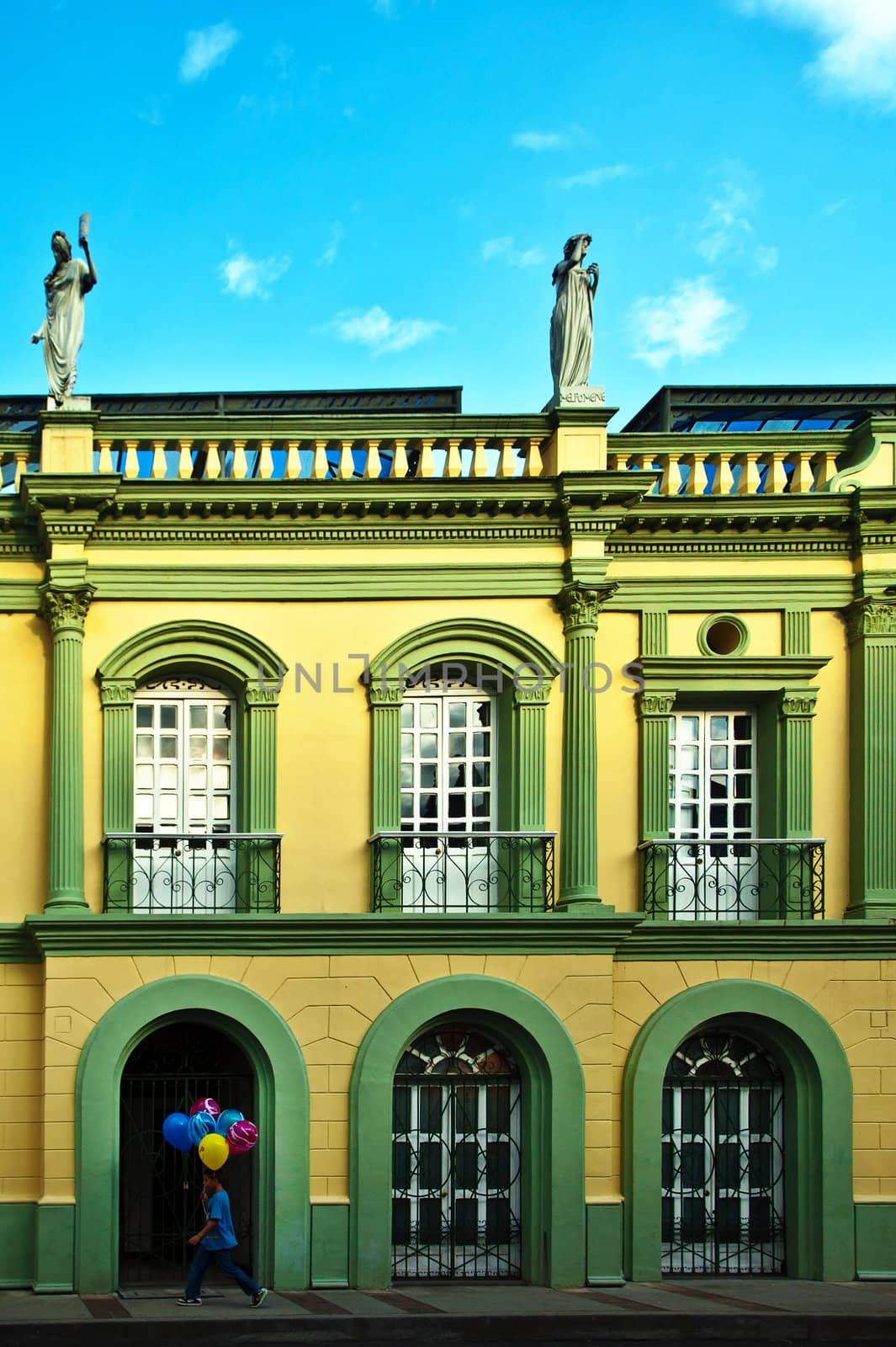 A young boy walking down the street with balloons in Popayan, Colombia.