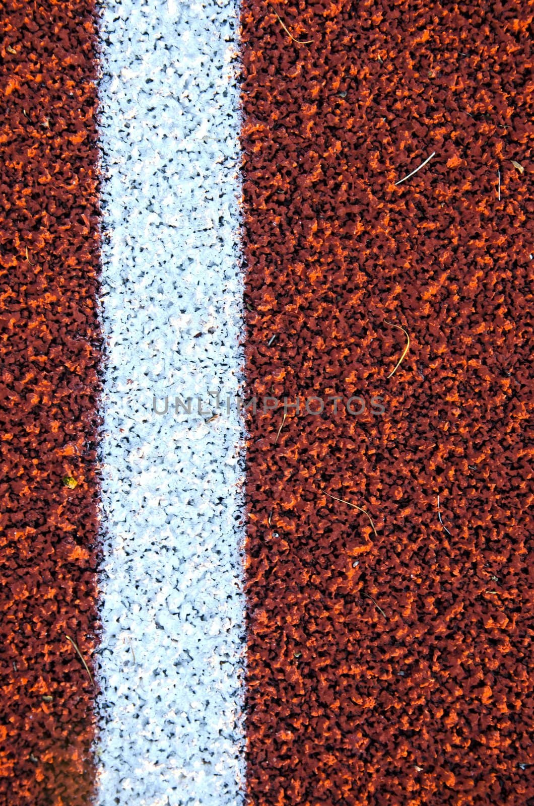 Stadium running track surface closeup background. Interesting textures.