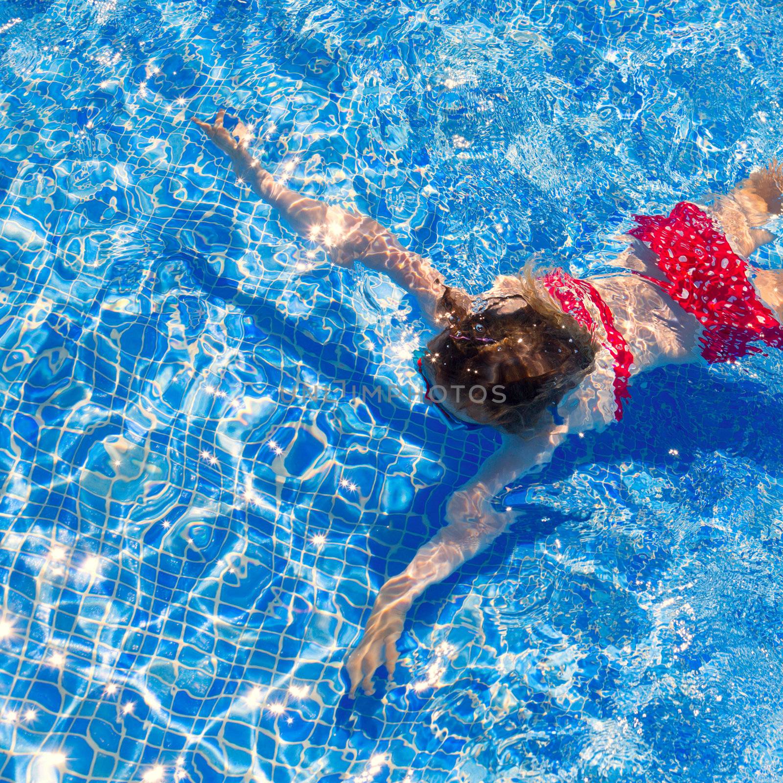 bikini kid girl swimming on blue tiles pool in summer vacation