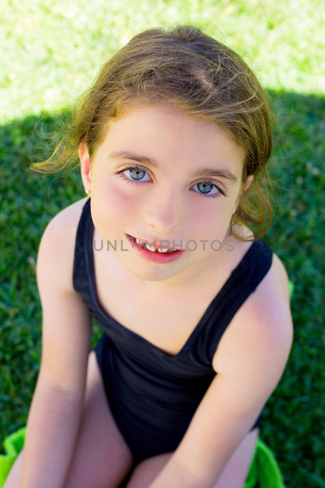 brunette children girl smiling with black swimming suit on garden grass