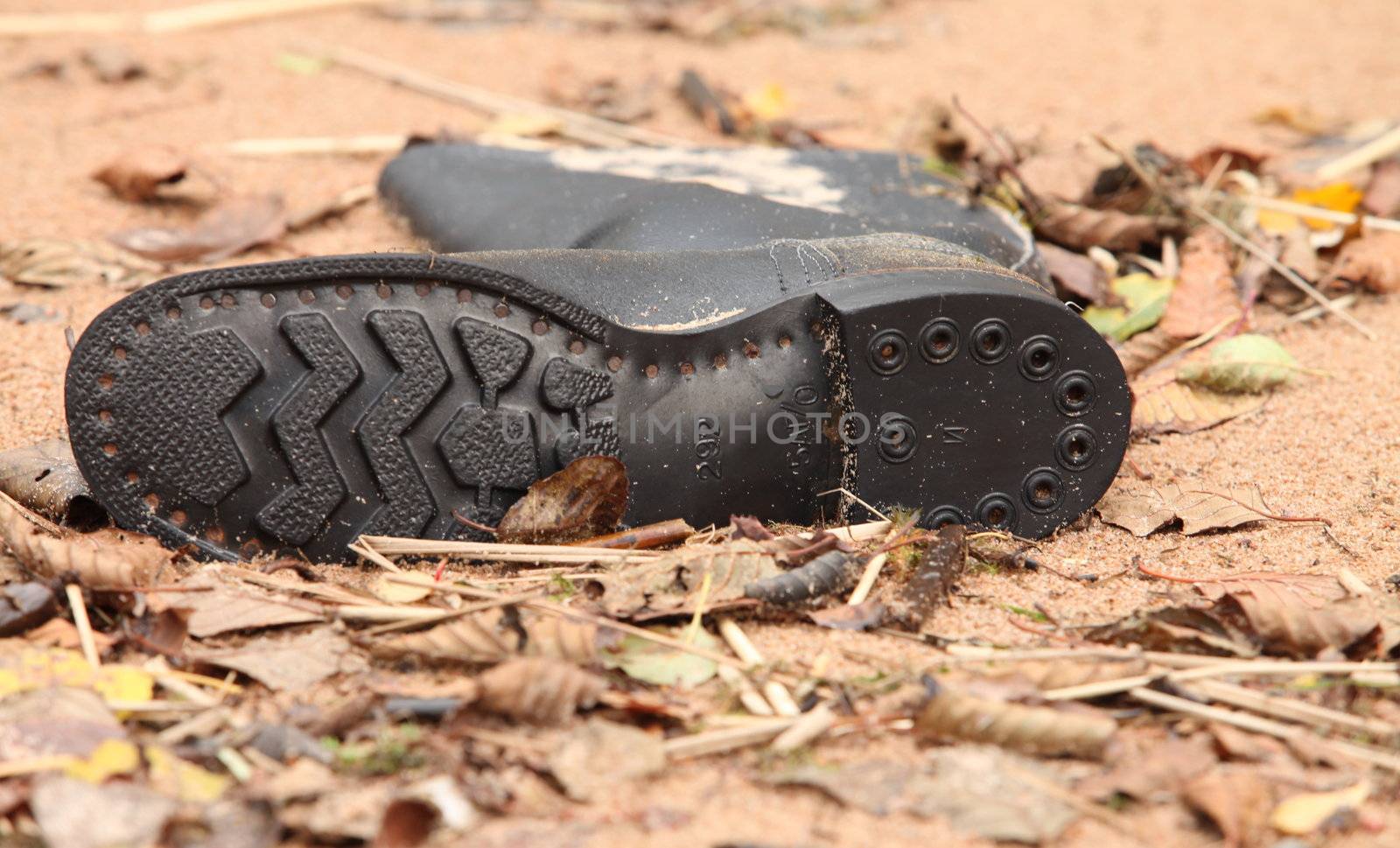 soldier tarpaulin boots in the sand on the beach after high tide