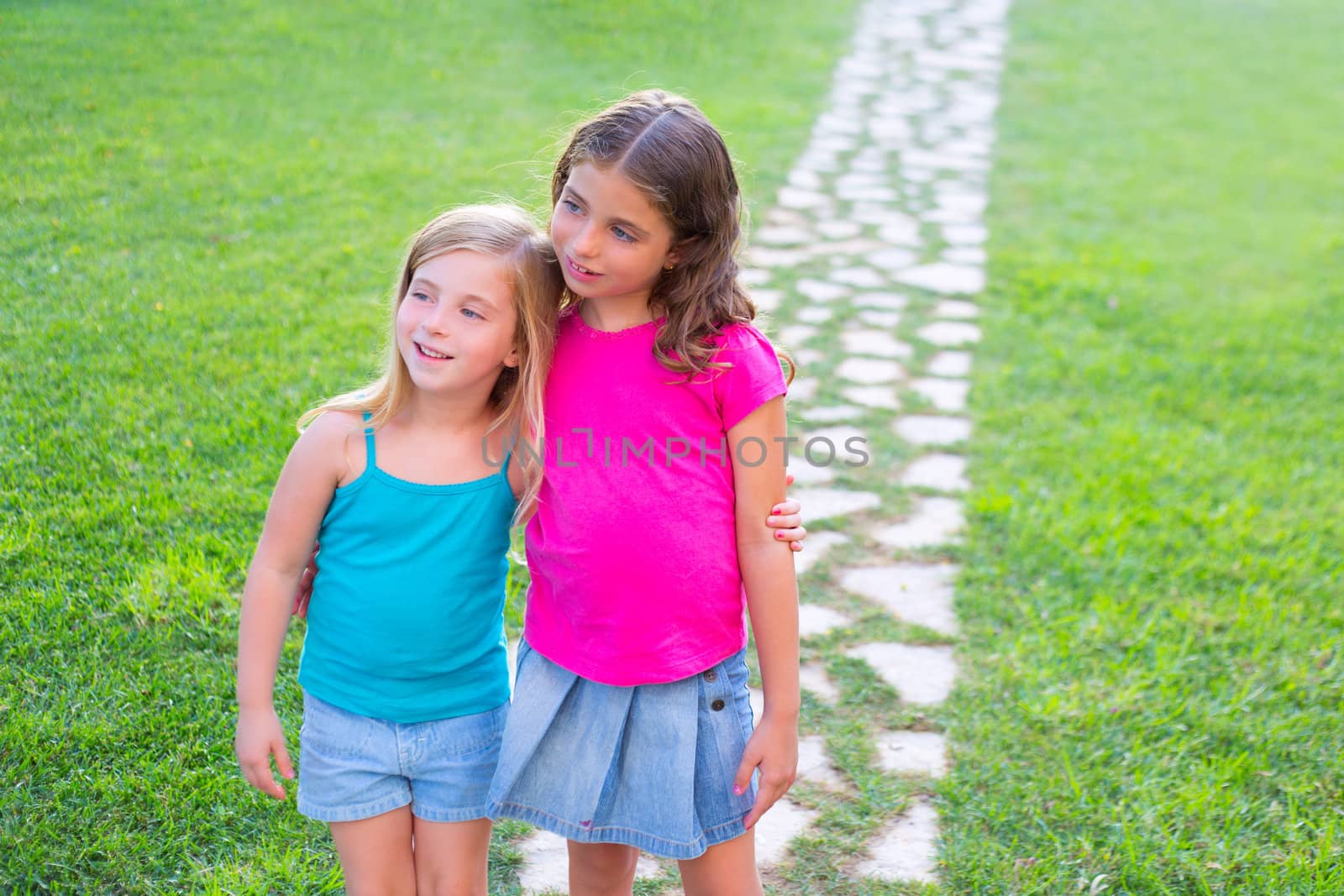 friends sister girls together in grass garden track hugging eachother