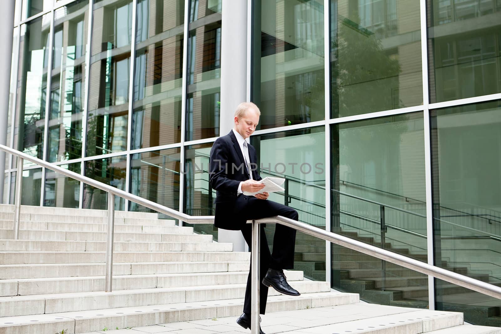 succsessful business man with tie and black dress reading newspaper