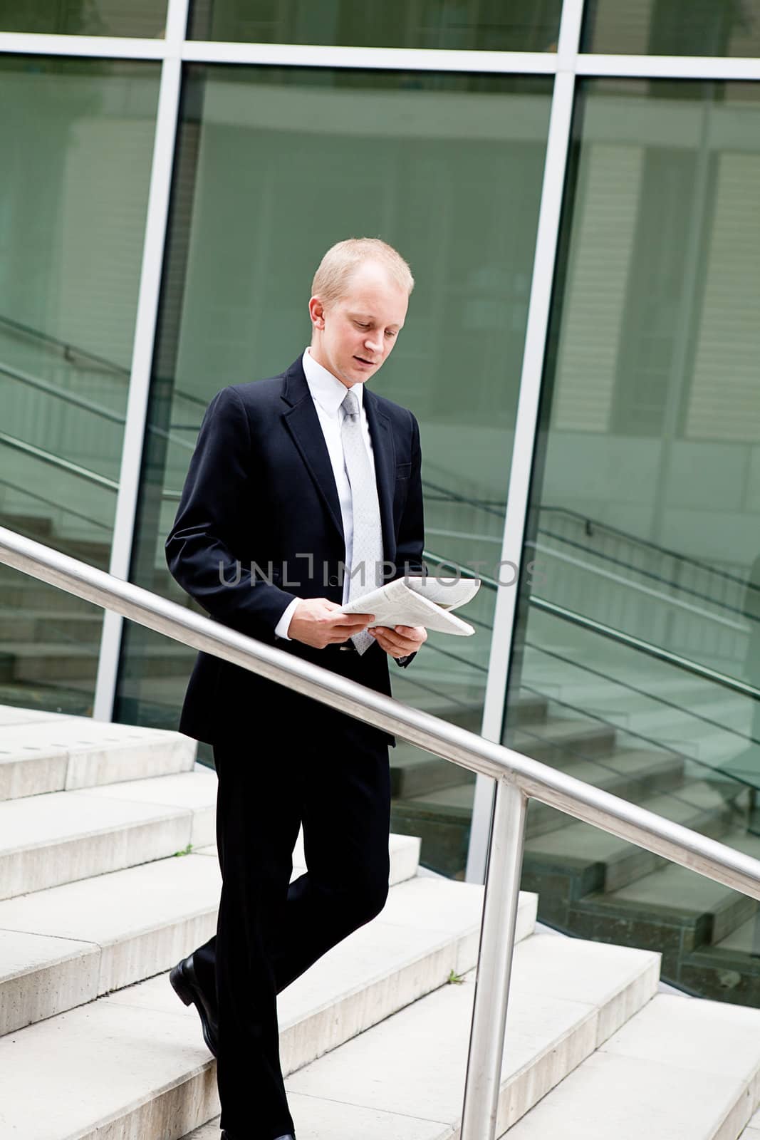 succsessful business man with tie and black dress reading newspaper