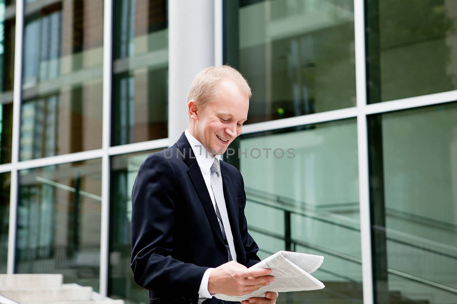 succsessful business man with tie and black dress reading newspaper