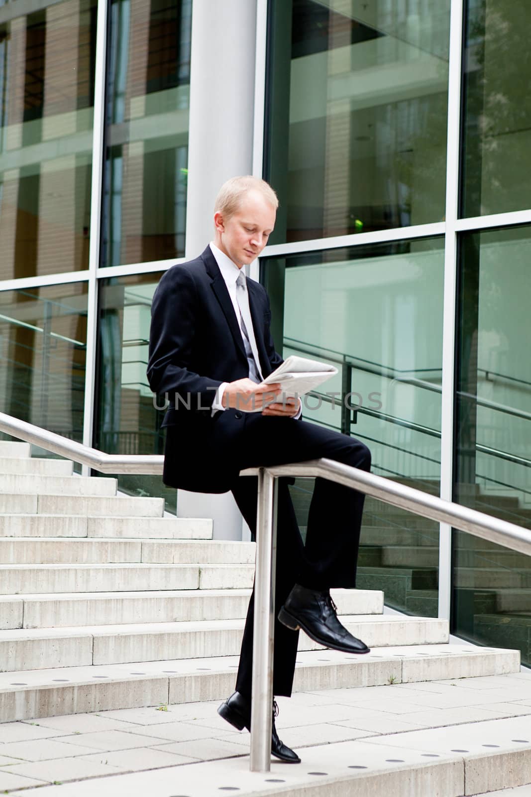 succsessful business man with tie and black dress reading newspaper