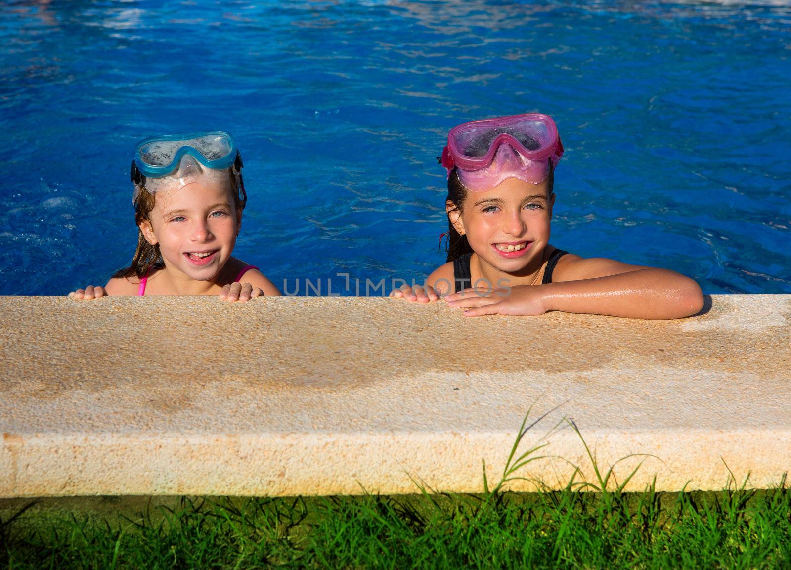 Blue eyes children girls on on blue pool poolside smiling with snorkel glasses