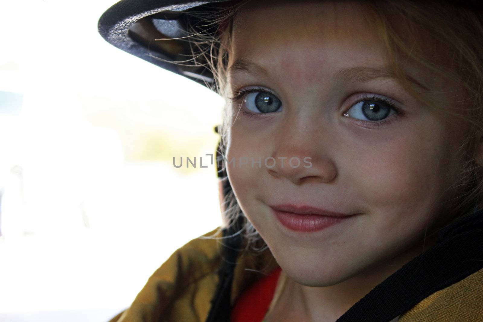 A young girl dressed as firefighter, closeup