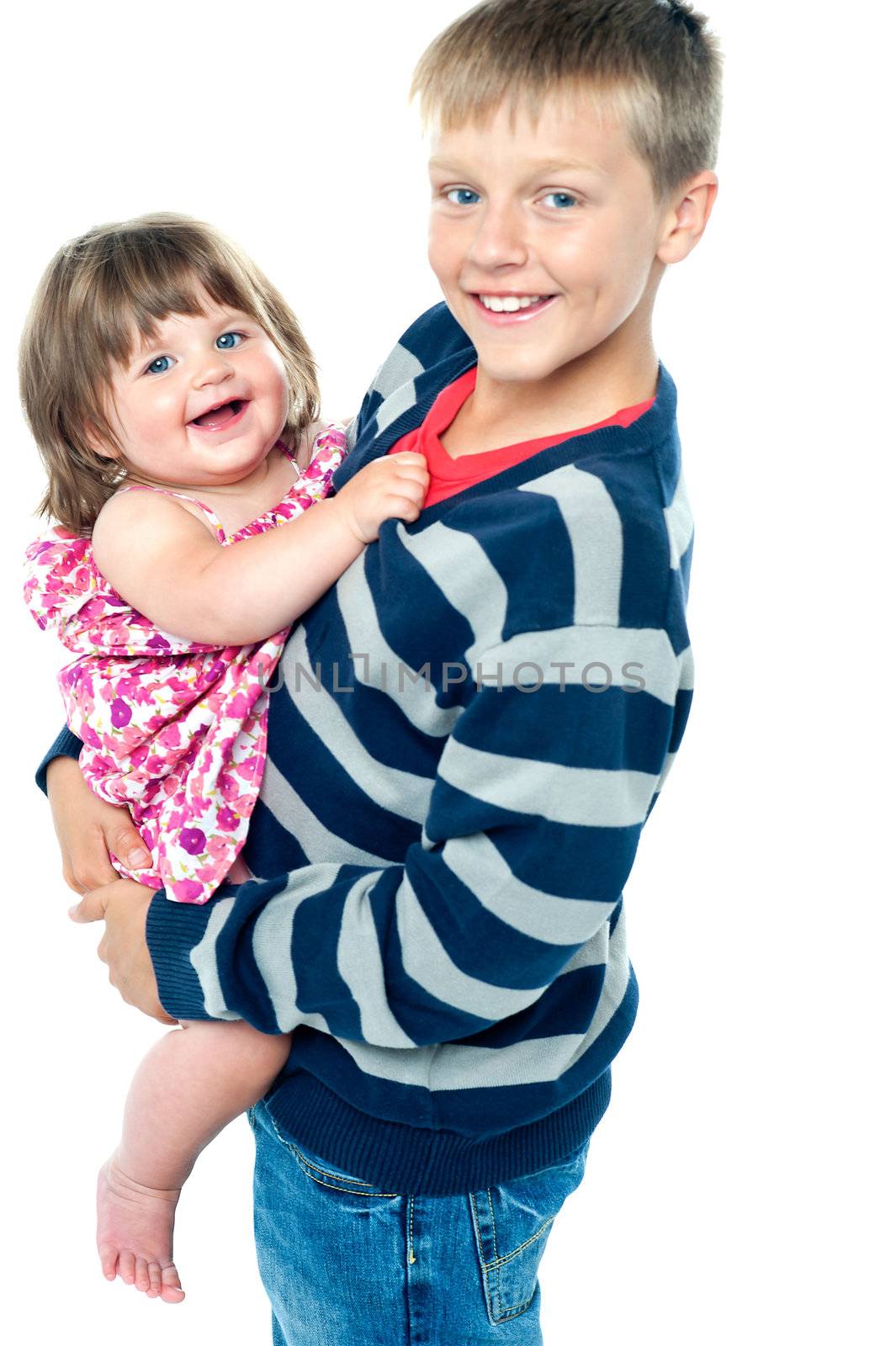 Loving young brother carrying his sweet little toddler sister by stockyimages