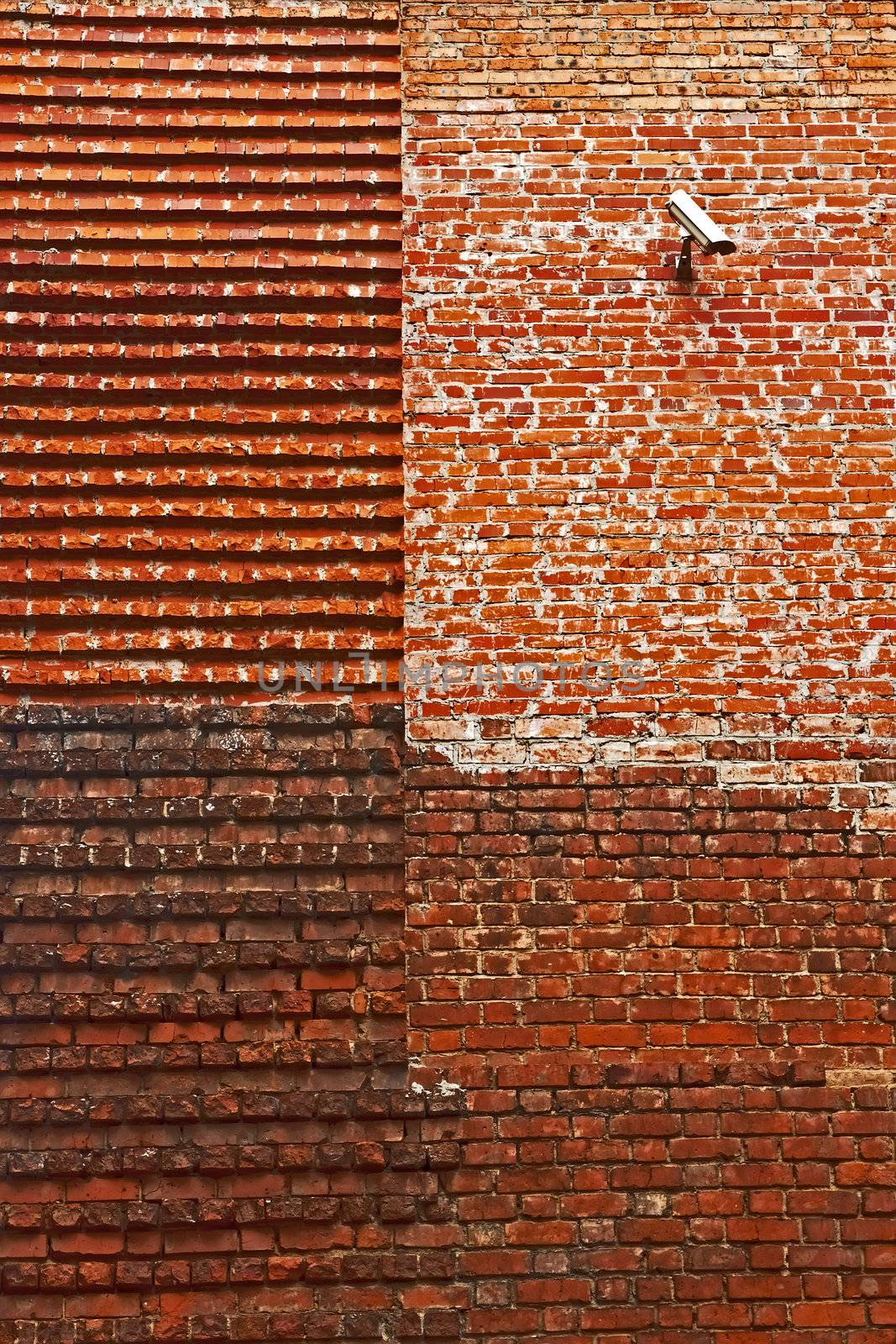 Detail of the restored medieval brick walls. On the old basis built on a new part. Surveillance camera at the top. Lviv, Ukraine