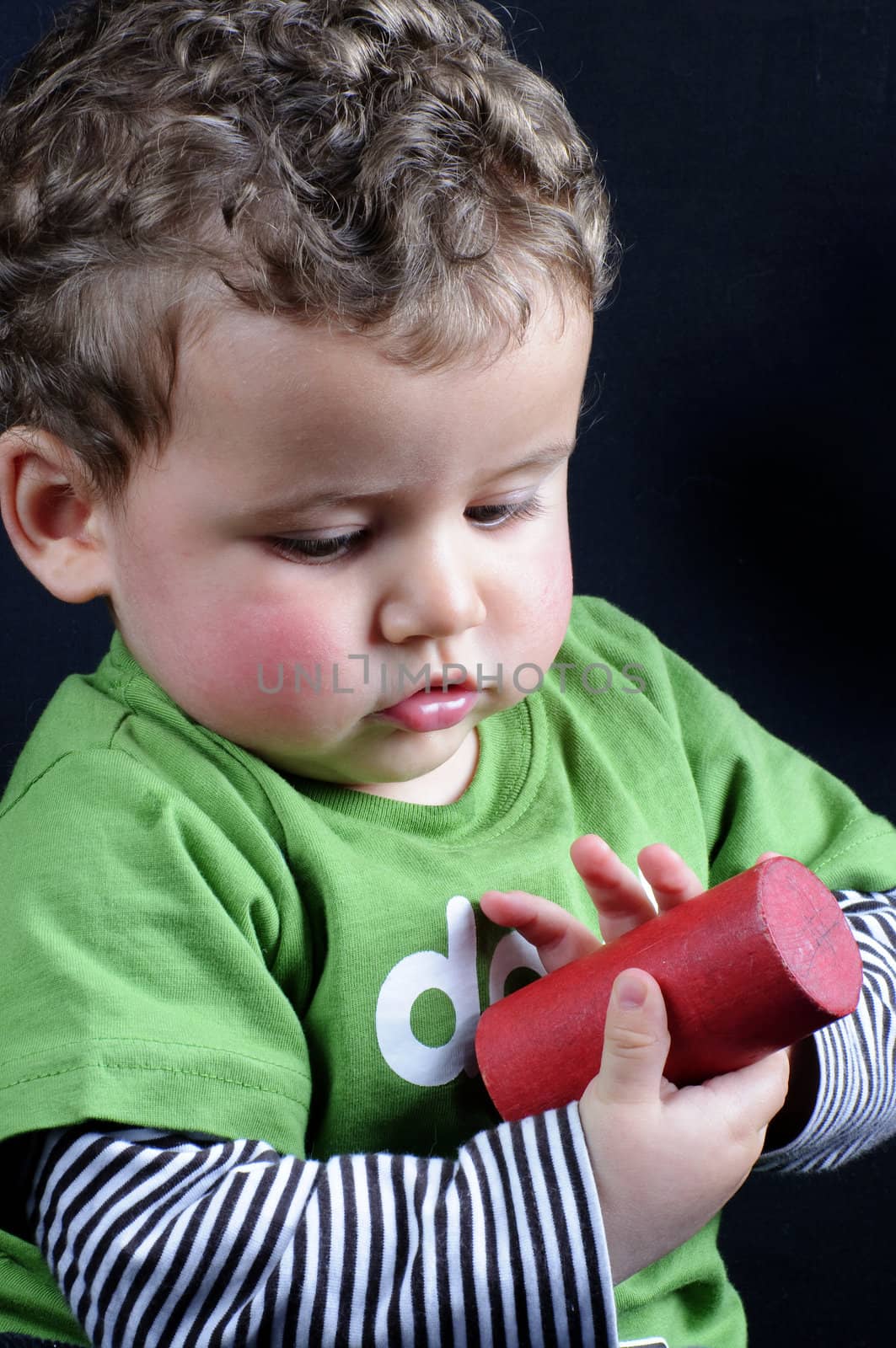 beautiful blond boy smiling and playing with colored blocks