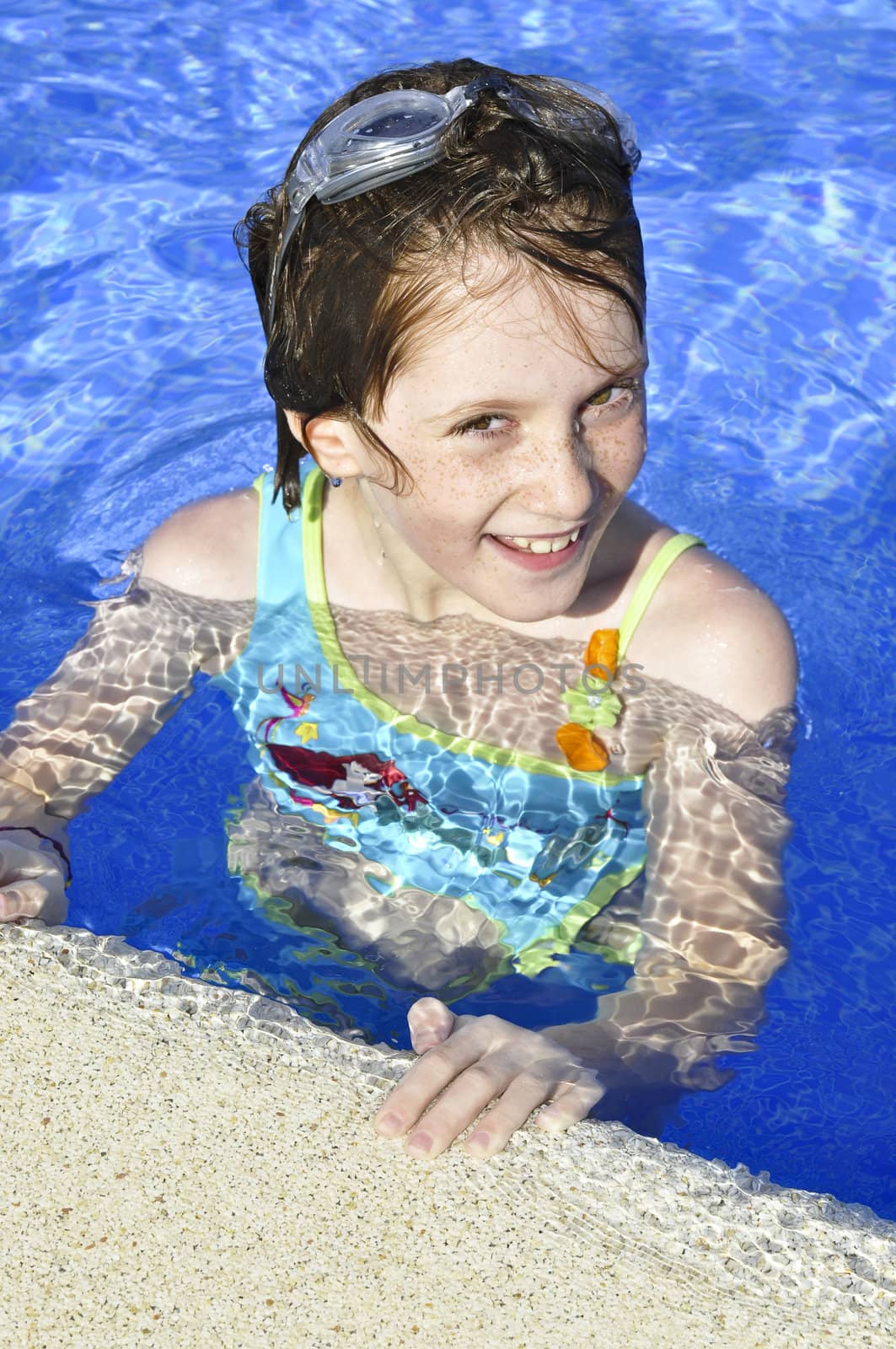 girl smiling and happy in the pool in summer