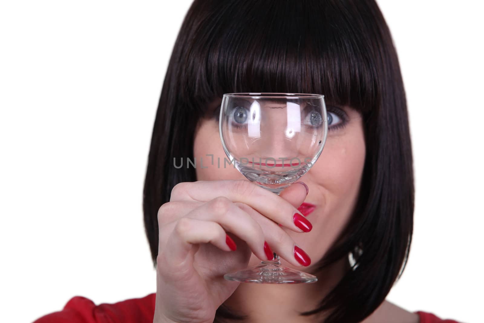 Woman watching meticulously an empty goblet by phovoir