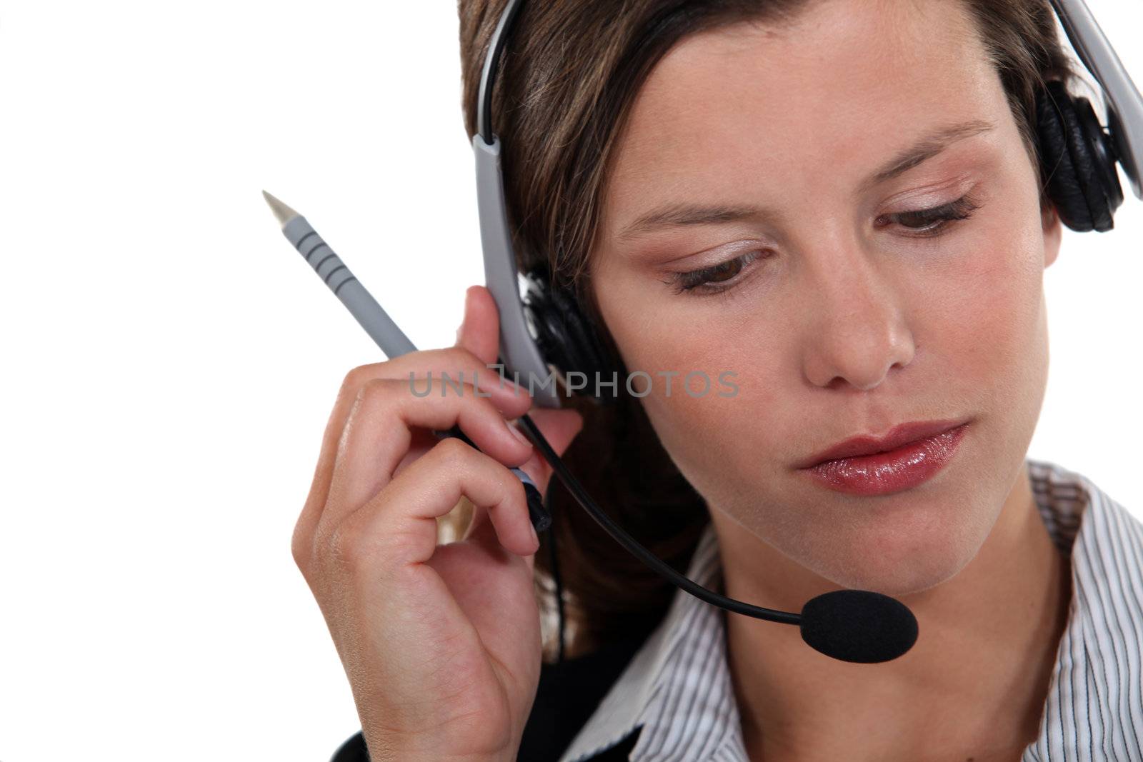 Brunette call-center worker listening to customer by phovoir