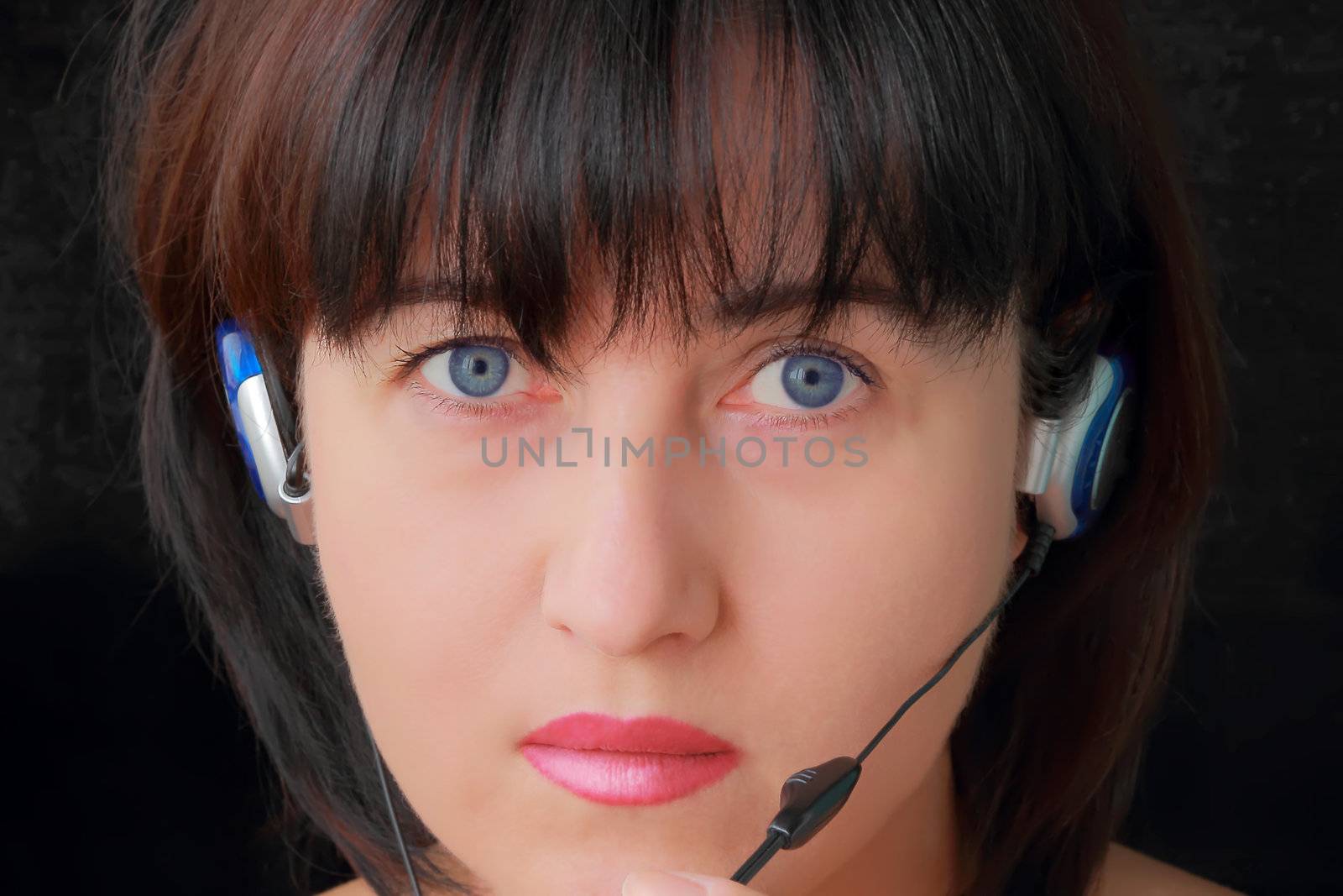 Portrait of young woman in earphone with blue eyes