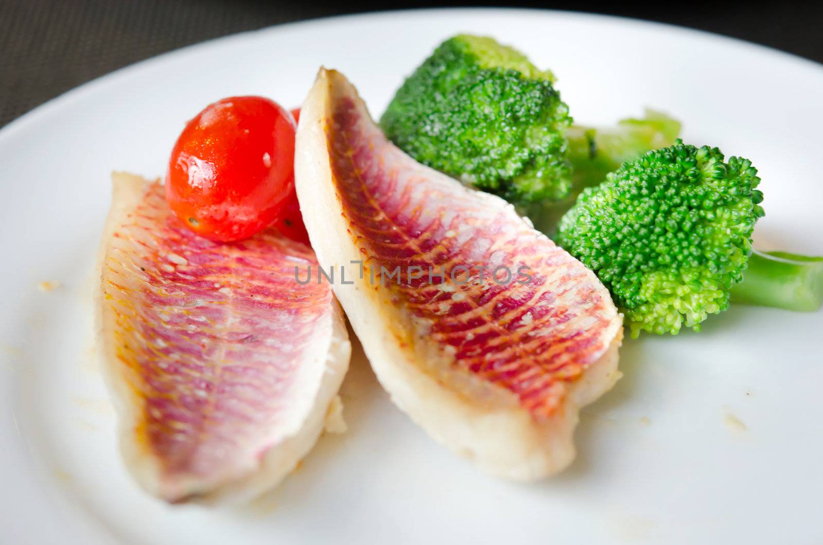 grilled fish  with fresh vegetable on white dish

