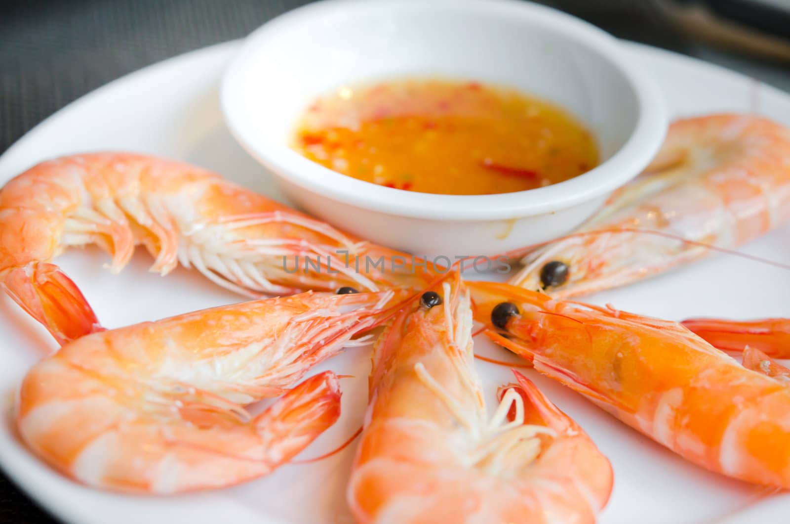 Boiled shrimps on plate served with spicy sauce