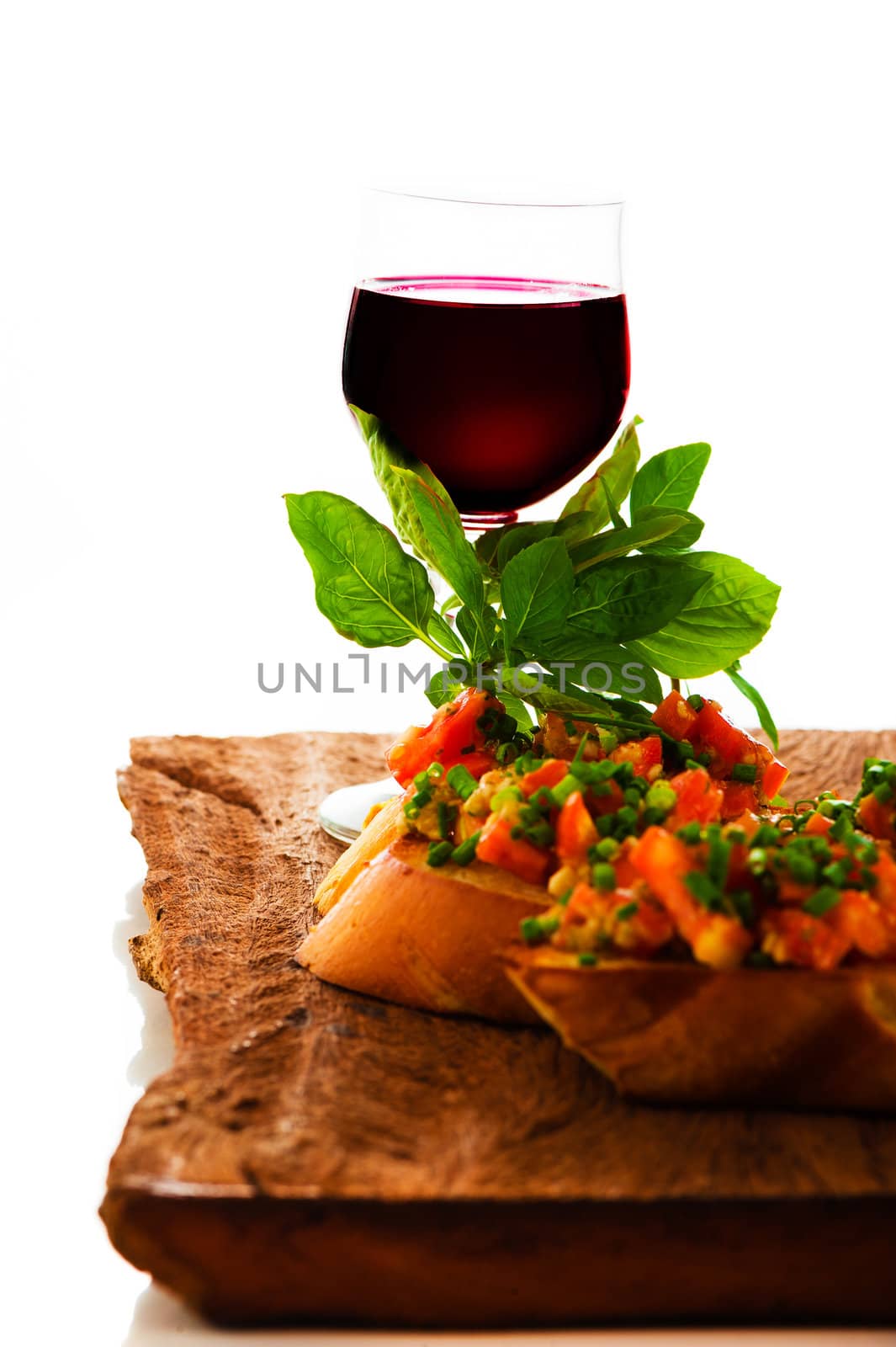 delicious bruschetta appetizer with red wine glass on wooden board