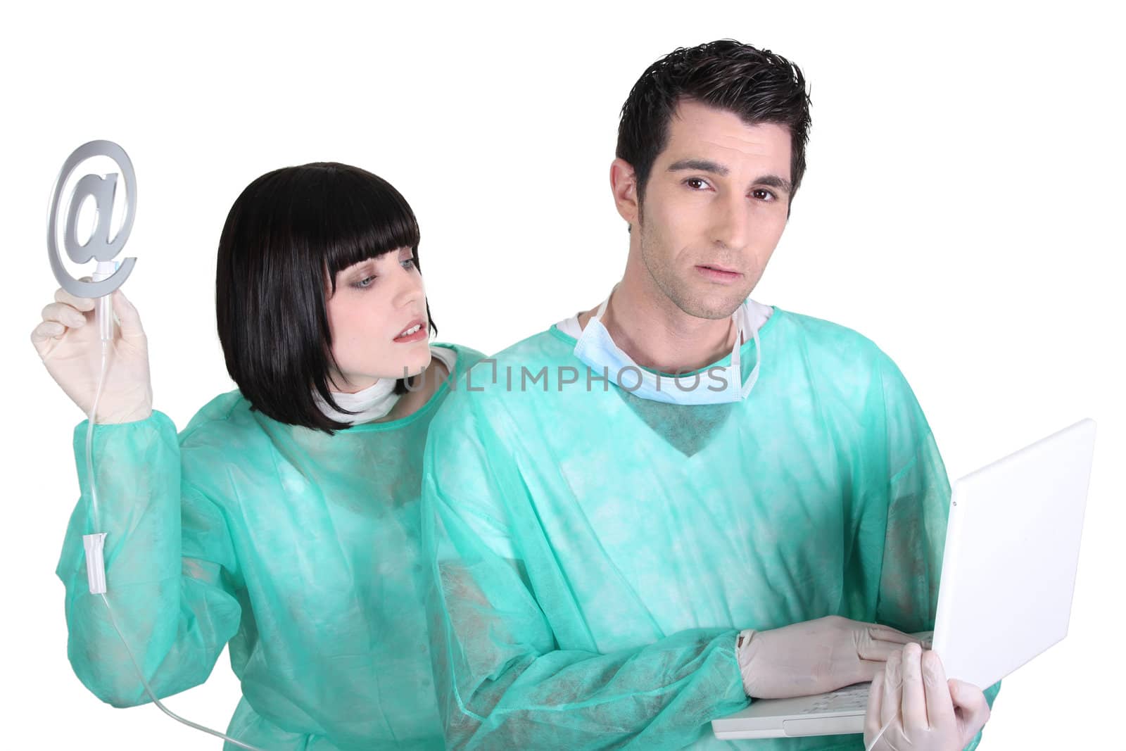 doctor and nurse holding a laptop and an at sign by phovoir