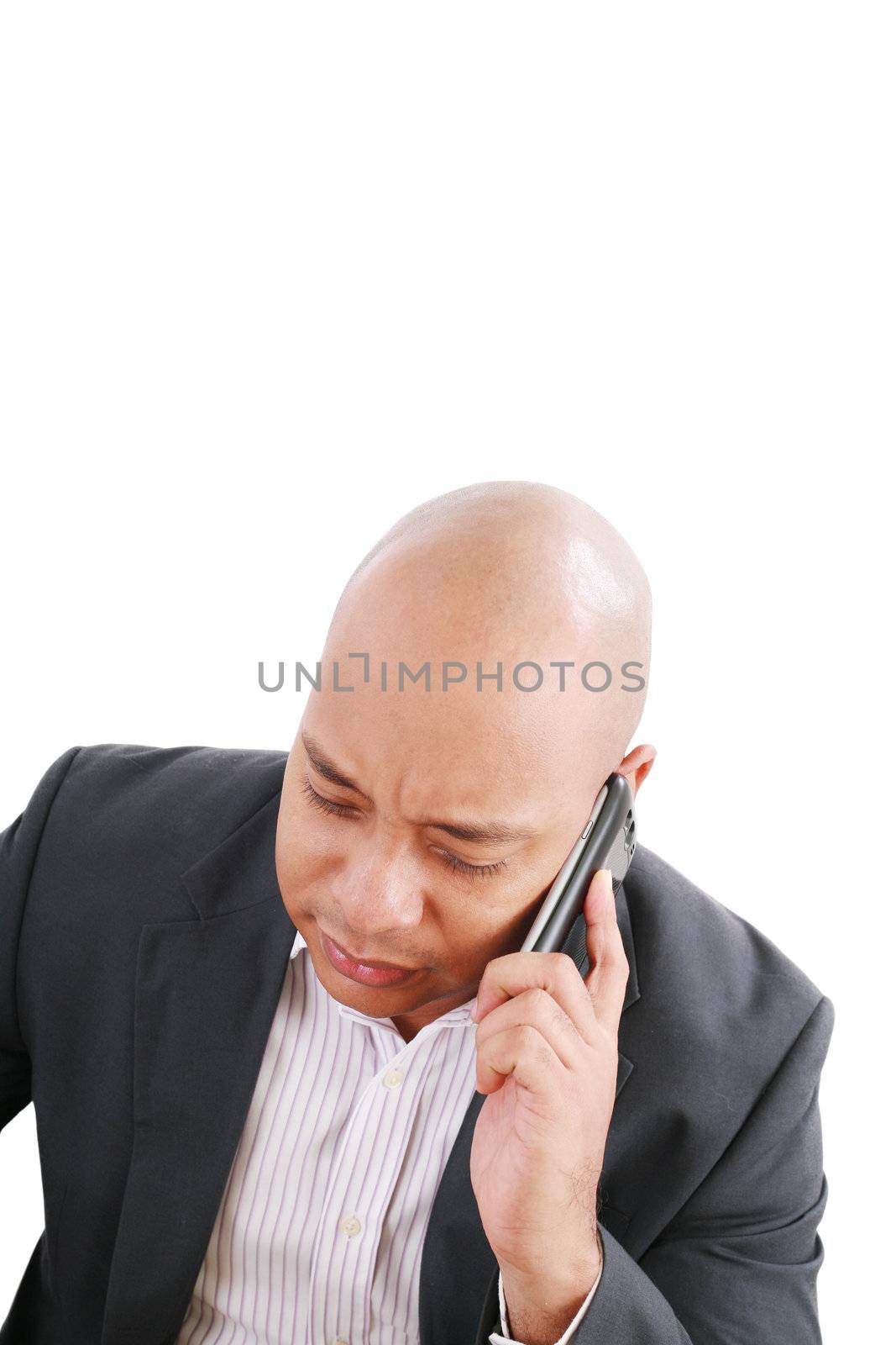 Portrait of a serious businessman talking on mobile phone over w by dacasdo