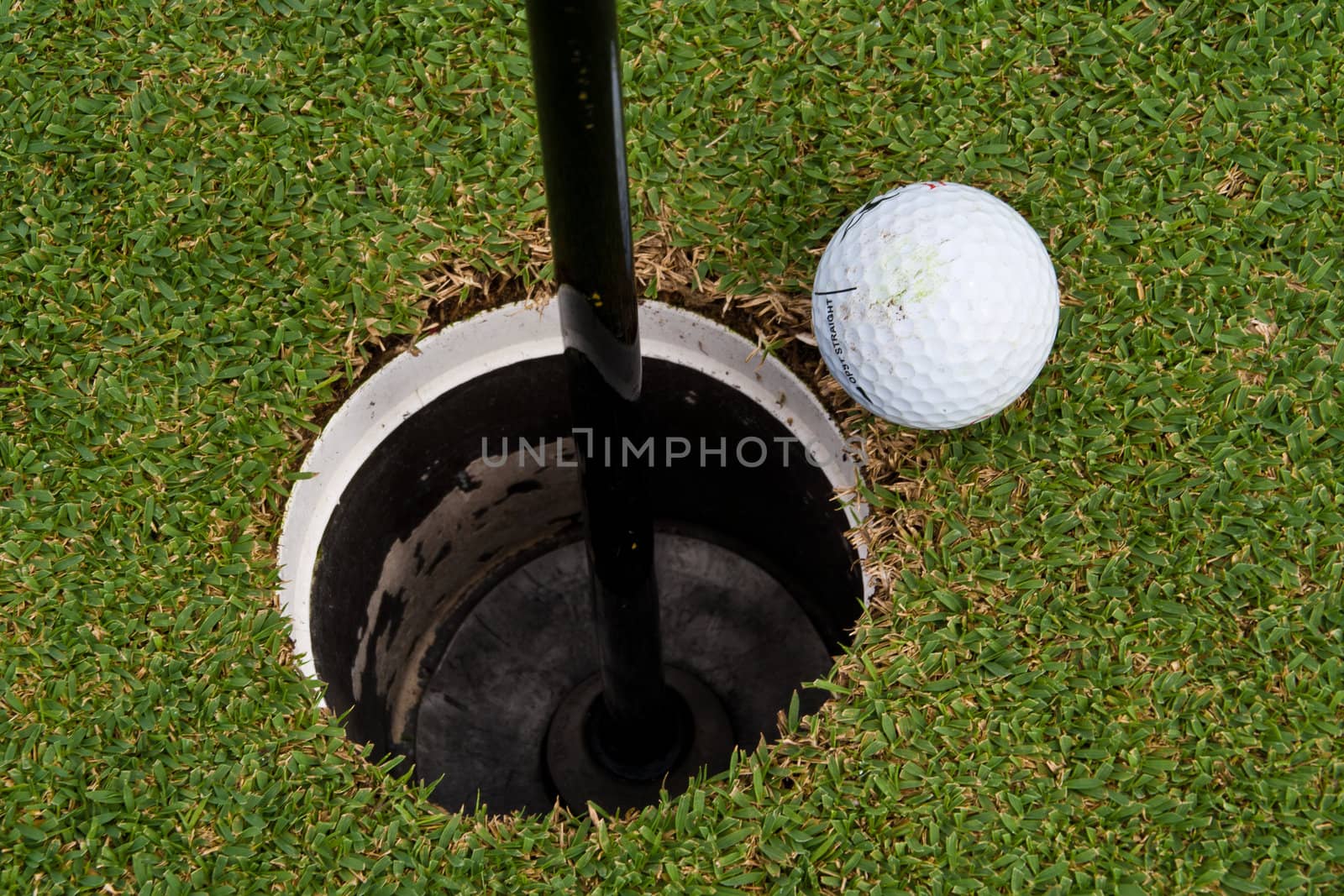 The golf holes, golf ball close to the hole.