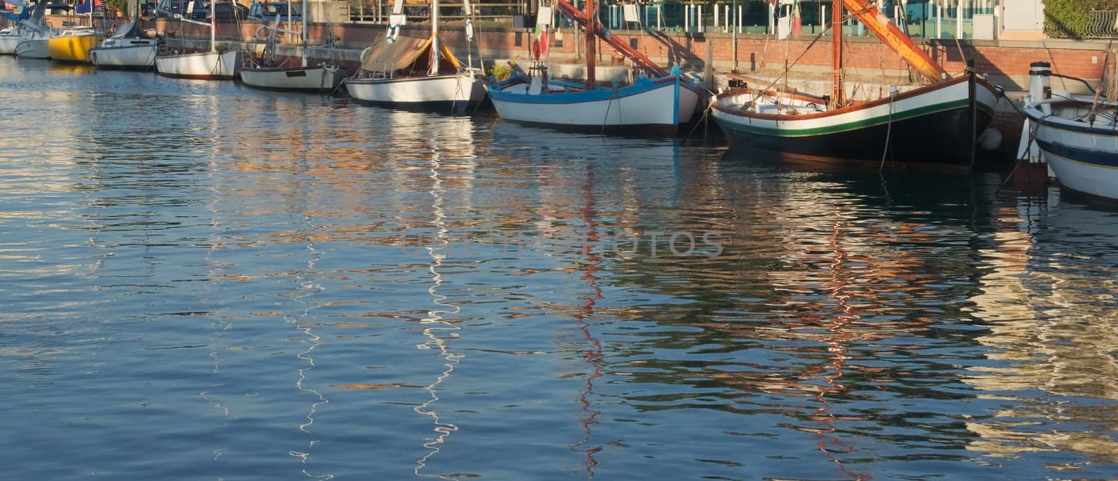 Fishing boats and reflections in Cervia in Italy in the early morning