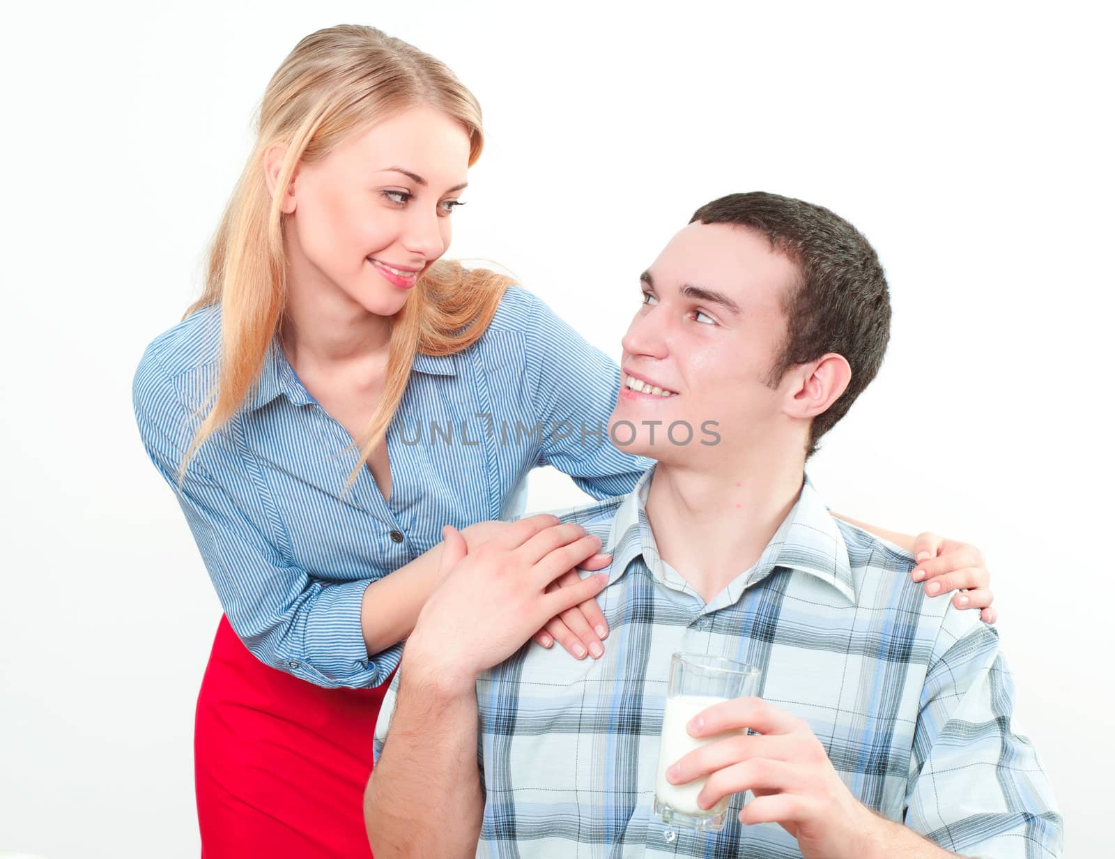 wife embraces the husband, he holds a glass of milk