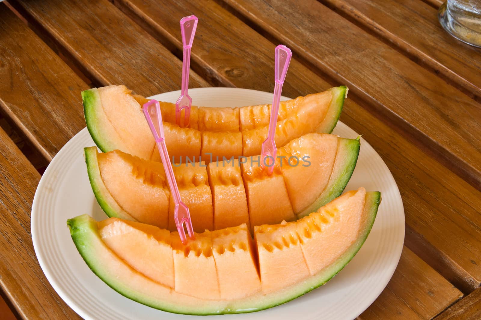 Yellow melon piece on a white plate.