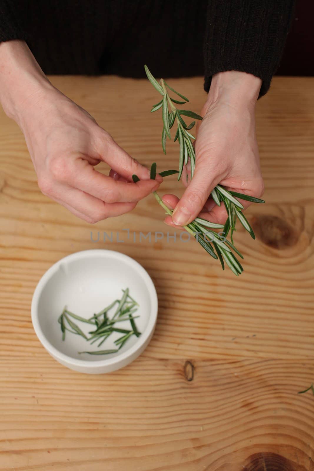 A bouquet of rosemary herbs on a weathered old chopping board.