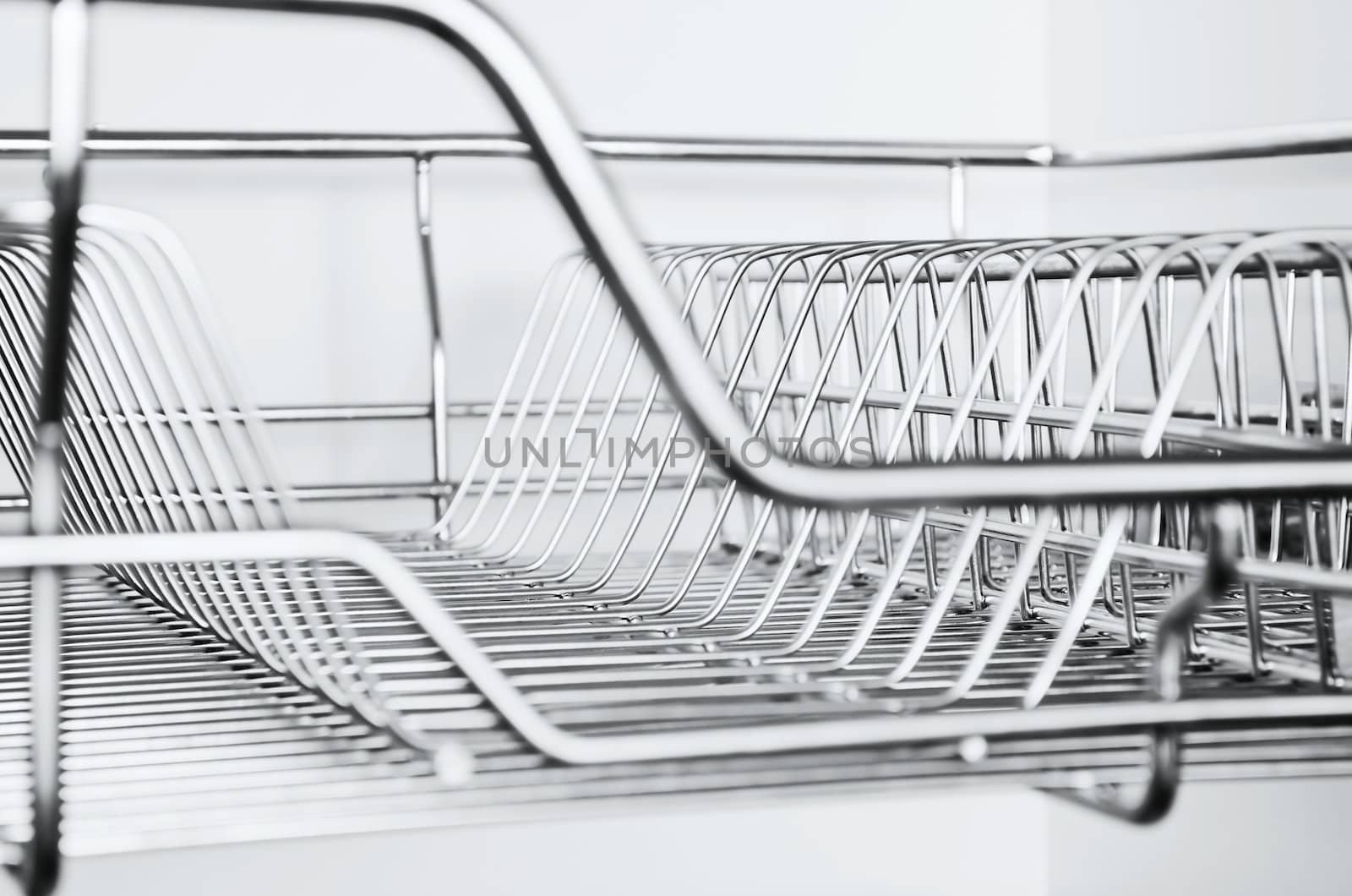 Close-up of stainless steel dish rack inside kitchen cabinet