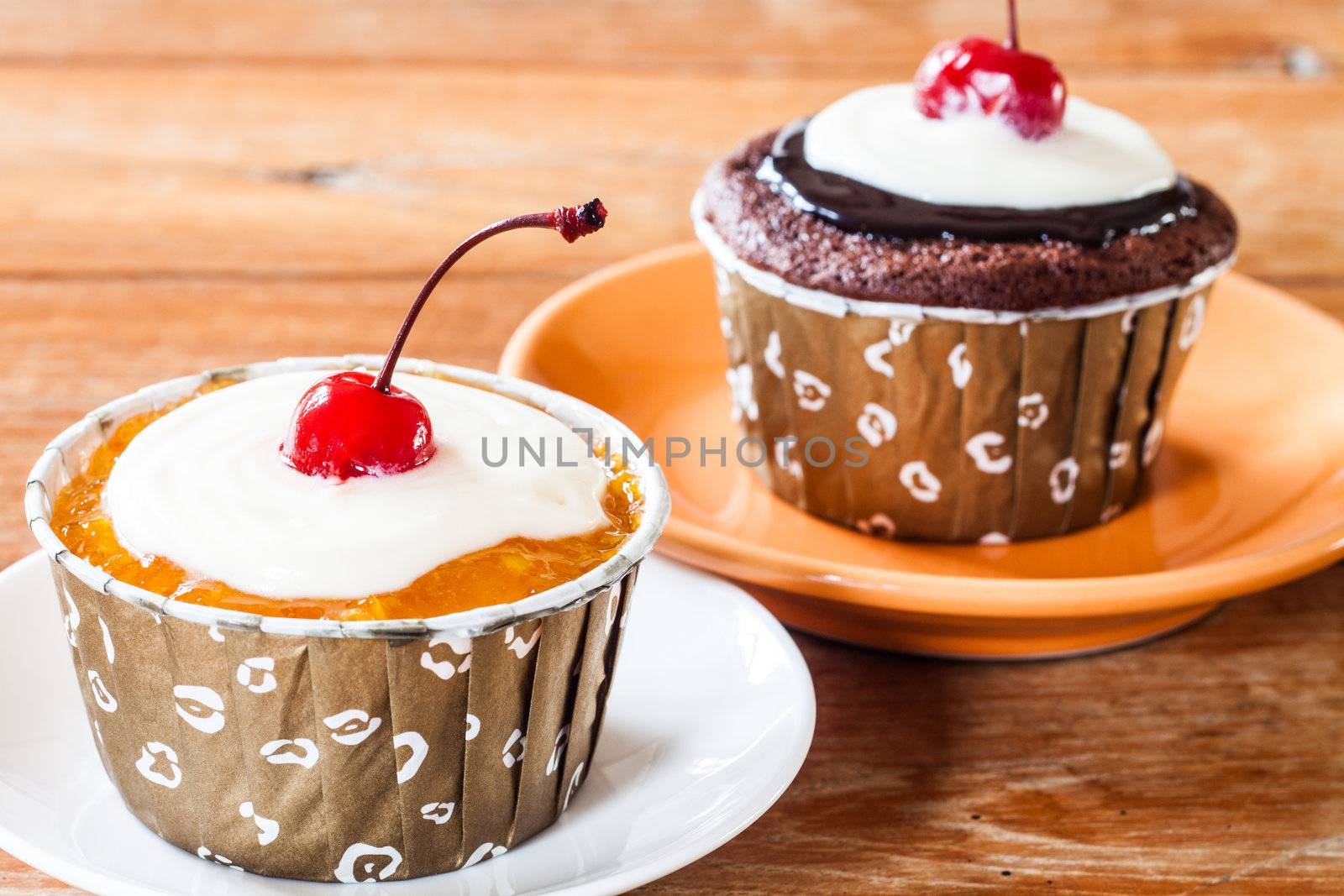 Chocolate and Butter Marmalade Cupcakes decorated with red cherry