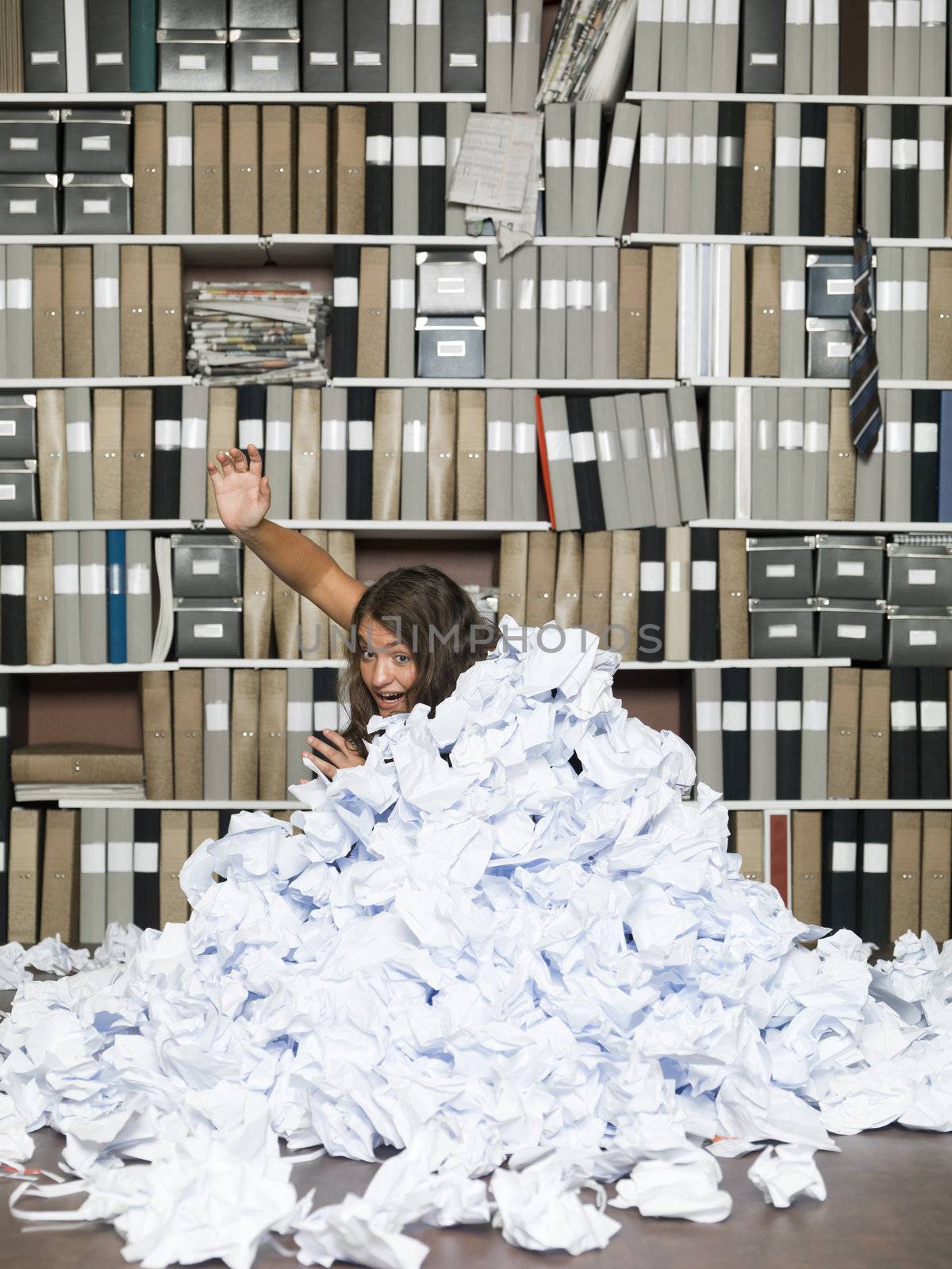 Young woman buried in papers at the office