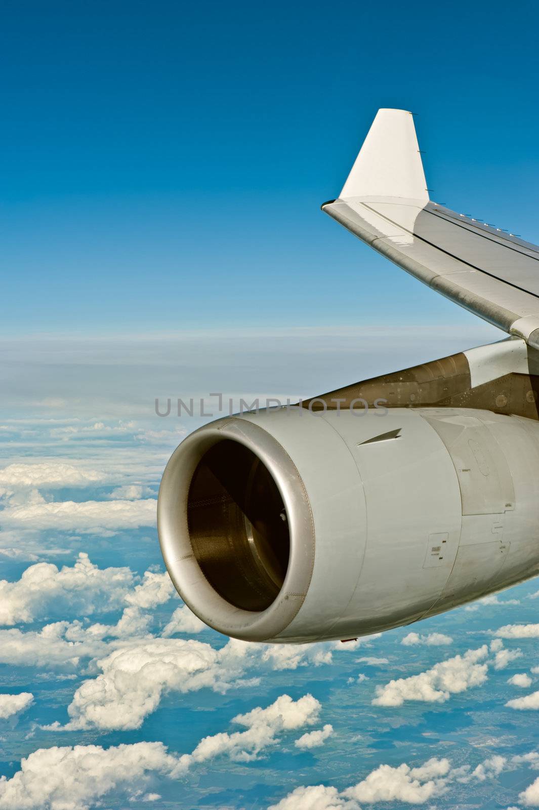 Jet engine of an airplane over the cloudscapea
