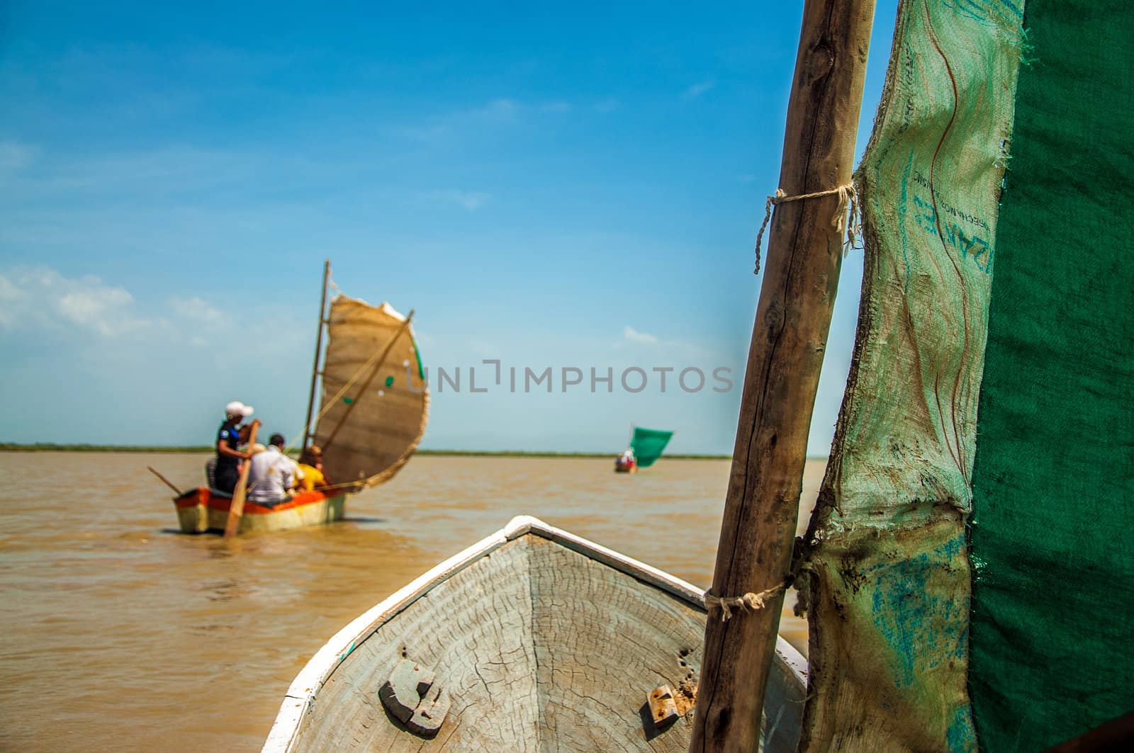 A first person view of three canoes on a lagoon.